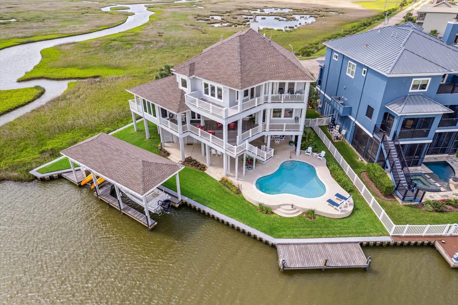 1 Shell Key, Hitchcock, TX 77563 Located on a cul-de-sac, featuring expansive IPE decks, a resort-style pool, and over 140 ft. of waterfront with a 15x40 boathouse, dual lifts, fishing pier and 297 sq.ft. climate controlled tackle room on the ground level