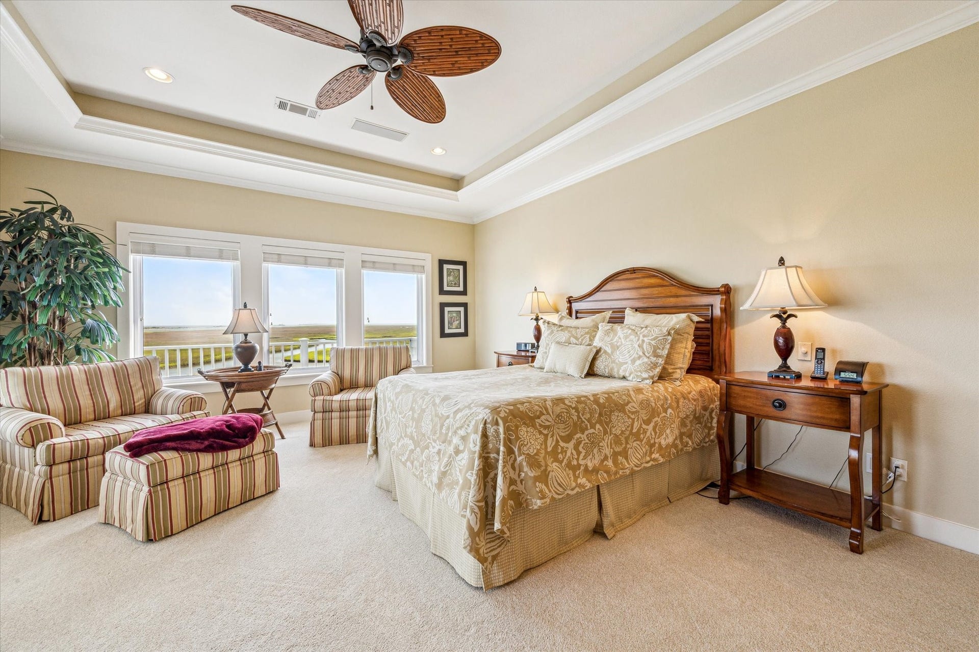 1 Shell Key, Hitchcock, TX 77563 The primary bedroom is a spacious and serene retreat, designed to maximize the breathtaking views of the surrounding coastal landscape with access to upper level covered & open deck. A tray ceiling with recessed lighting and a tropical-style ceiling fan adds an elegant, airy feel to the room