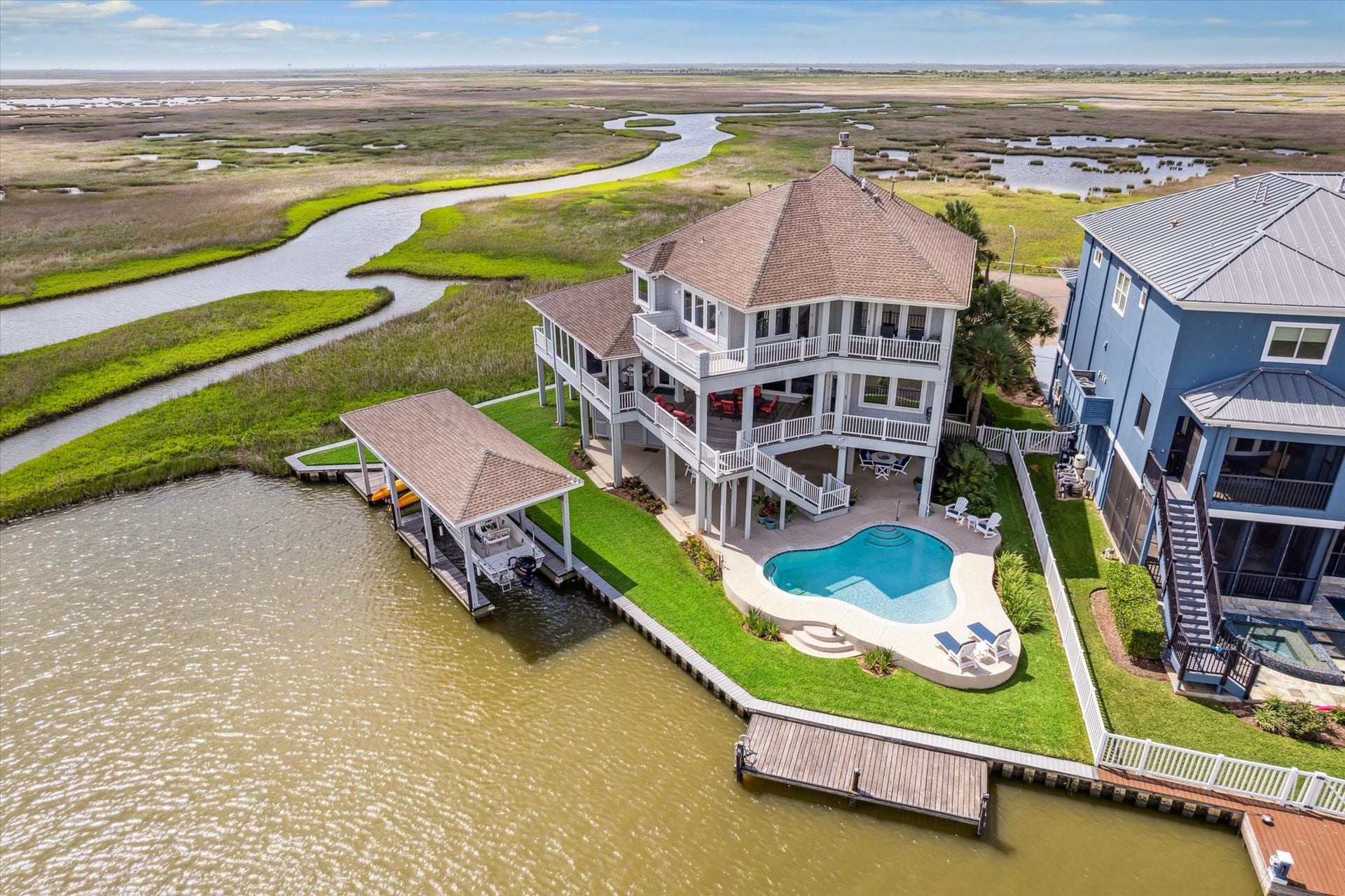 1 Shell Key, Hitchcock, TX 77563 Designed for coastal living, the home blends indoor-outdoor space with covered patios, custom built pool with spray-deck surround and lower floor patio. Direct water accessperfect for boating, birding, and fishing right from your backyard