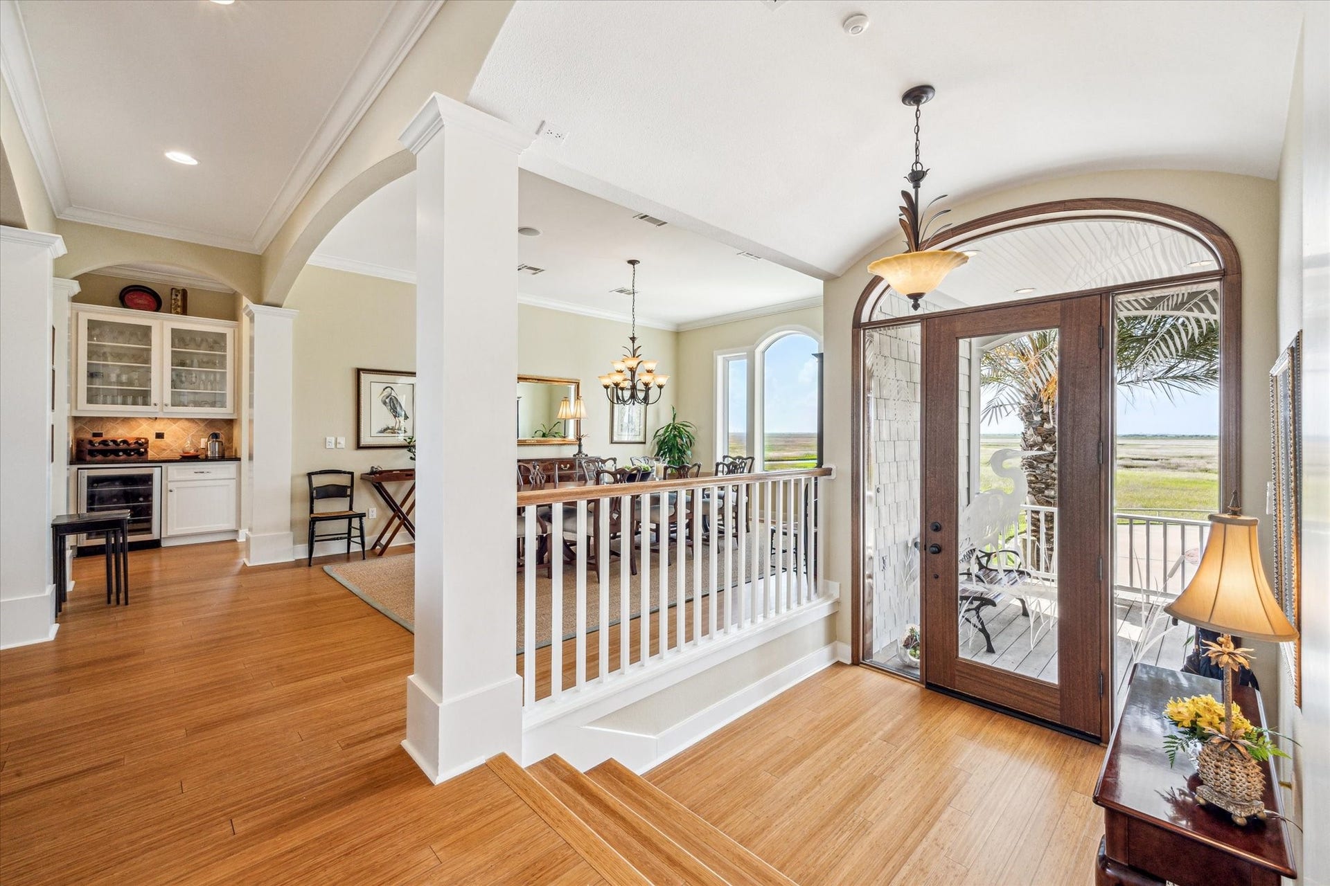 1 Shell Key, Hitchcock, TX 77563 This elegant entryway is filled with abundant natural light streaming through a large arched glass door. Classic architectural details, including column accents and wide trim, lend a sense of timeless elegance throughout this coastal retreat