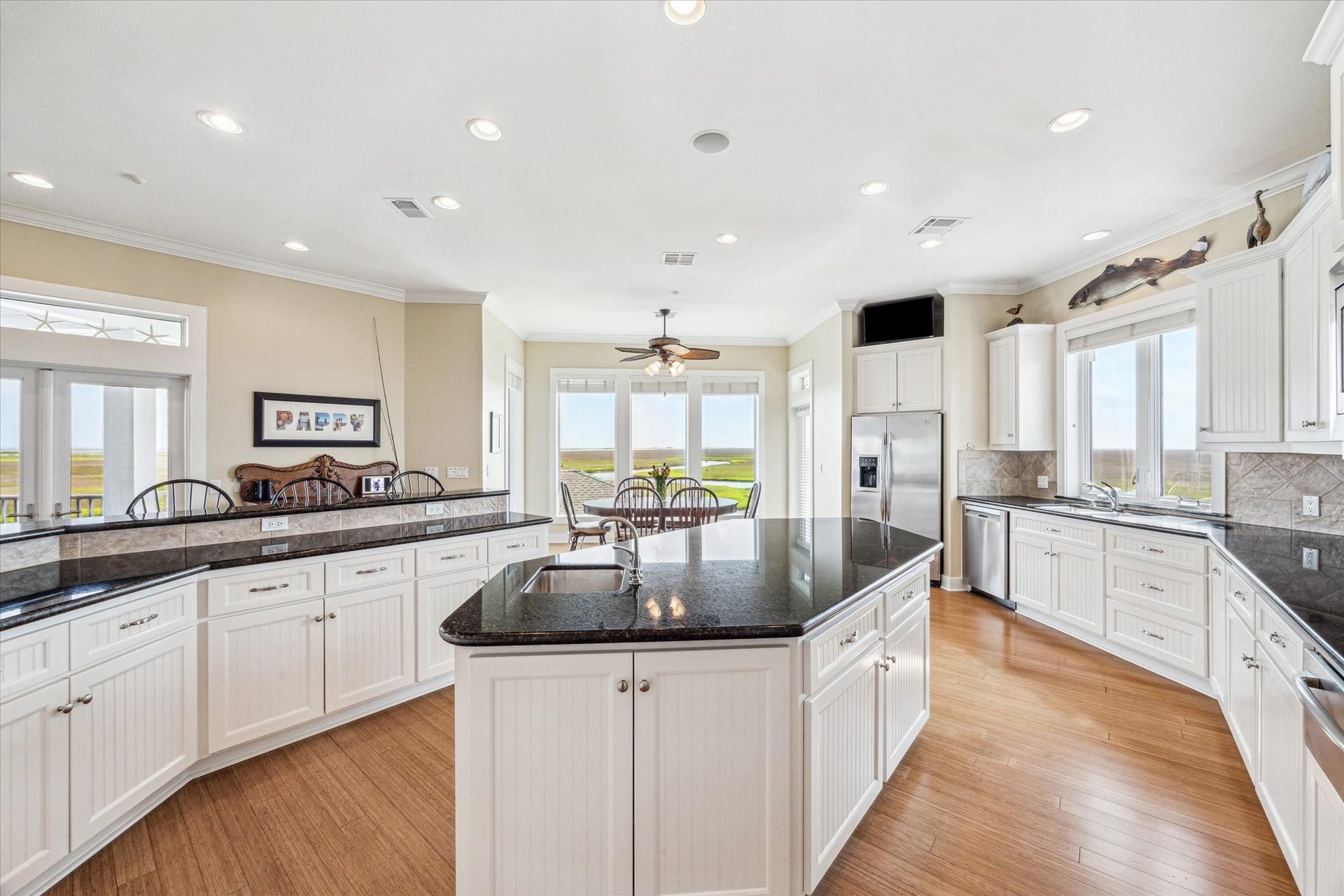 1 Shell Key, Hitchcock, TX 77563 The kitchen features custom white beadboard cabinets that bring timeless design and coastal appeal, blending classic style with everyday functionality. Enjoy the ease of indoor/outdoor entertaining with direct access to a separte sunset deck from the kitchen
