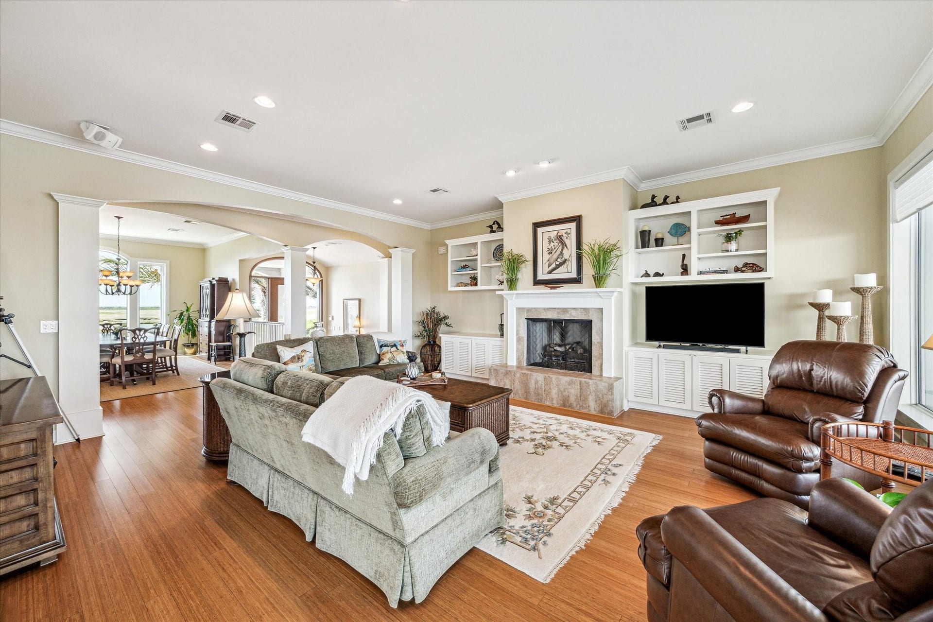 1 Shell Key, Hitchcock, TX 77563 A 42" wood burning fireplace with gas log and custom built-in entertainment center anchor the space, which flows effortlessly into the kitchen and dining areas. Ceiling fans in every room enhance airflow and comfort, creating a welcoming environment for everyday living and entertaining