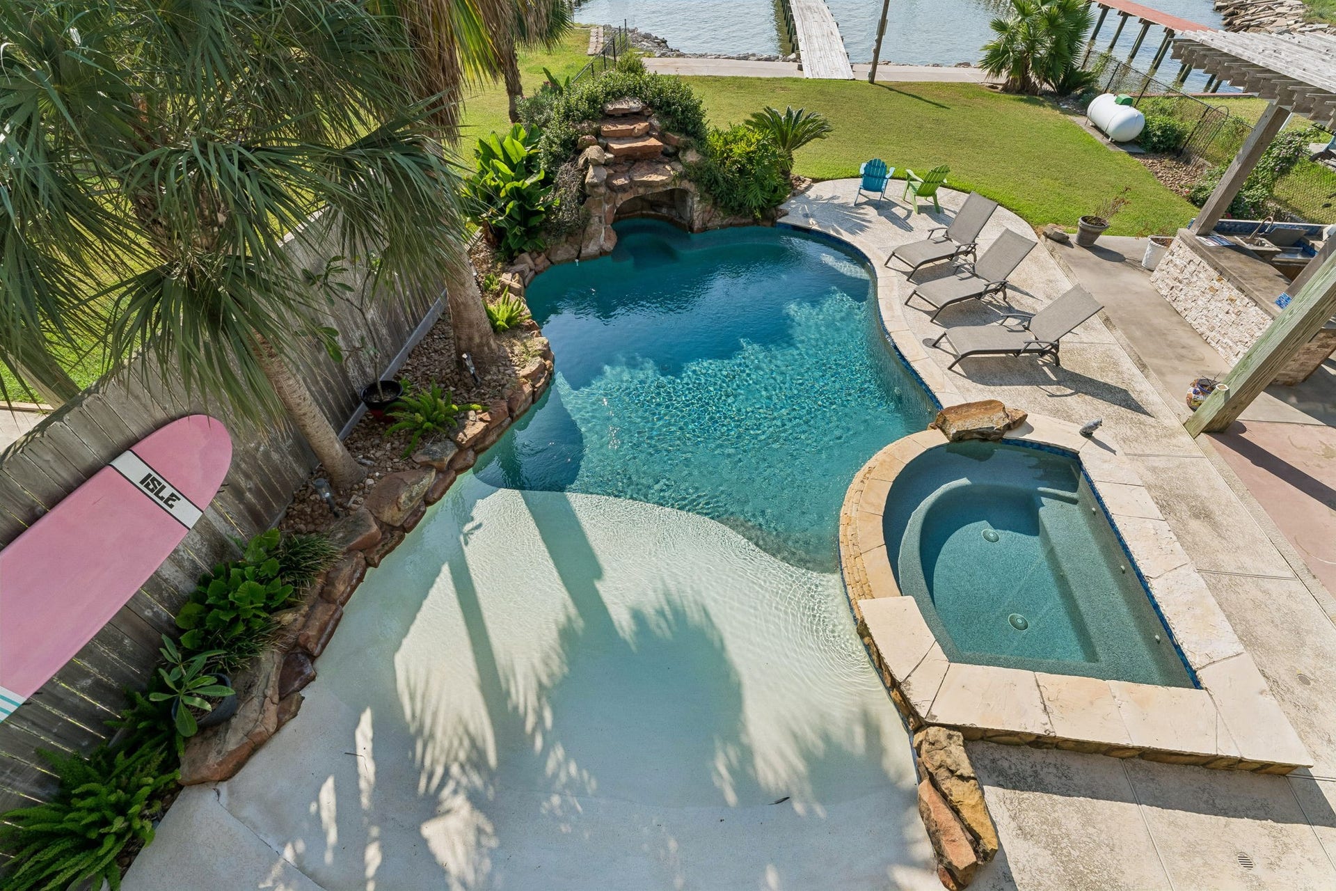 1623 Dick Bay Drive, San Leon, TX 77539 Resort style pool features a beach entry, built in hot tub, and cascading waterfall surrounded by tropical landscaping. Multiple lounging areas invite you to soak up the sun with Galveston Bay just beyond.