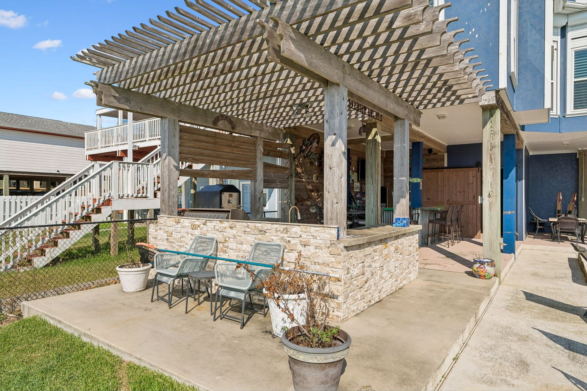 1623 Dick Bay Drive, San Leon, TX 77539 Pergola covered patio extends the outdoor entertaining space with additional seating beside the kitchen and bar. Stone accents and open air design create an inviting place to gather near the waterfront.