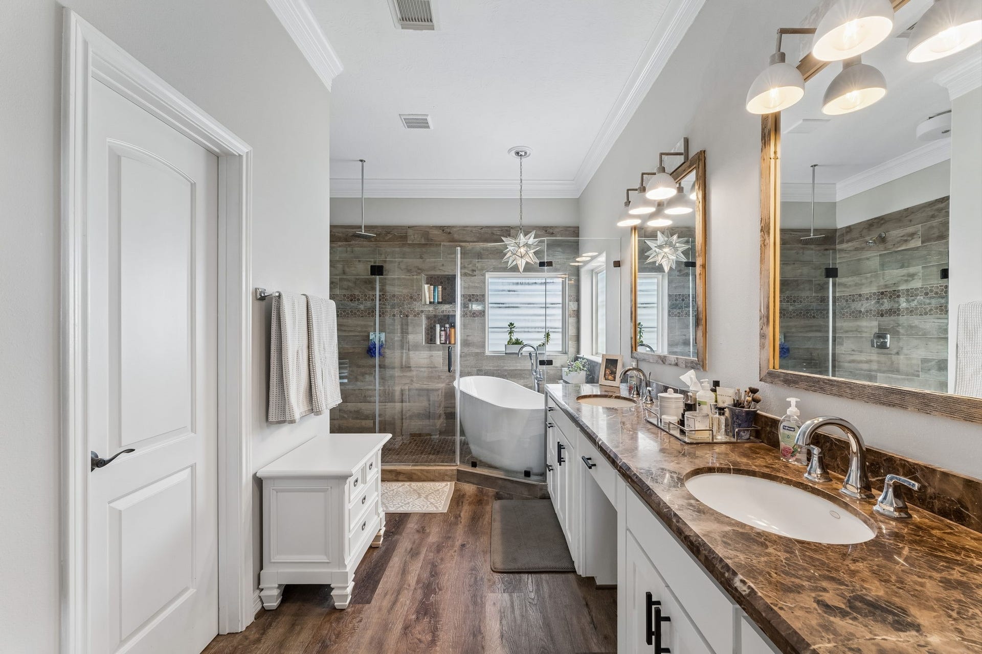 1623 Dick Bay Drive, San Leon, TX 77539 Spa inspired primary ensuite features dual vanities, rich stone countertops, and a freestanding soaking tub. The expansive wet room creates a luxurious setting for everyday relaxation.