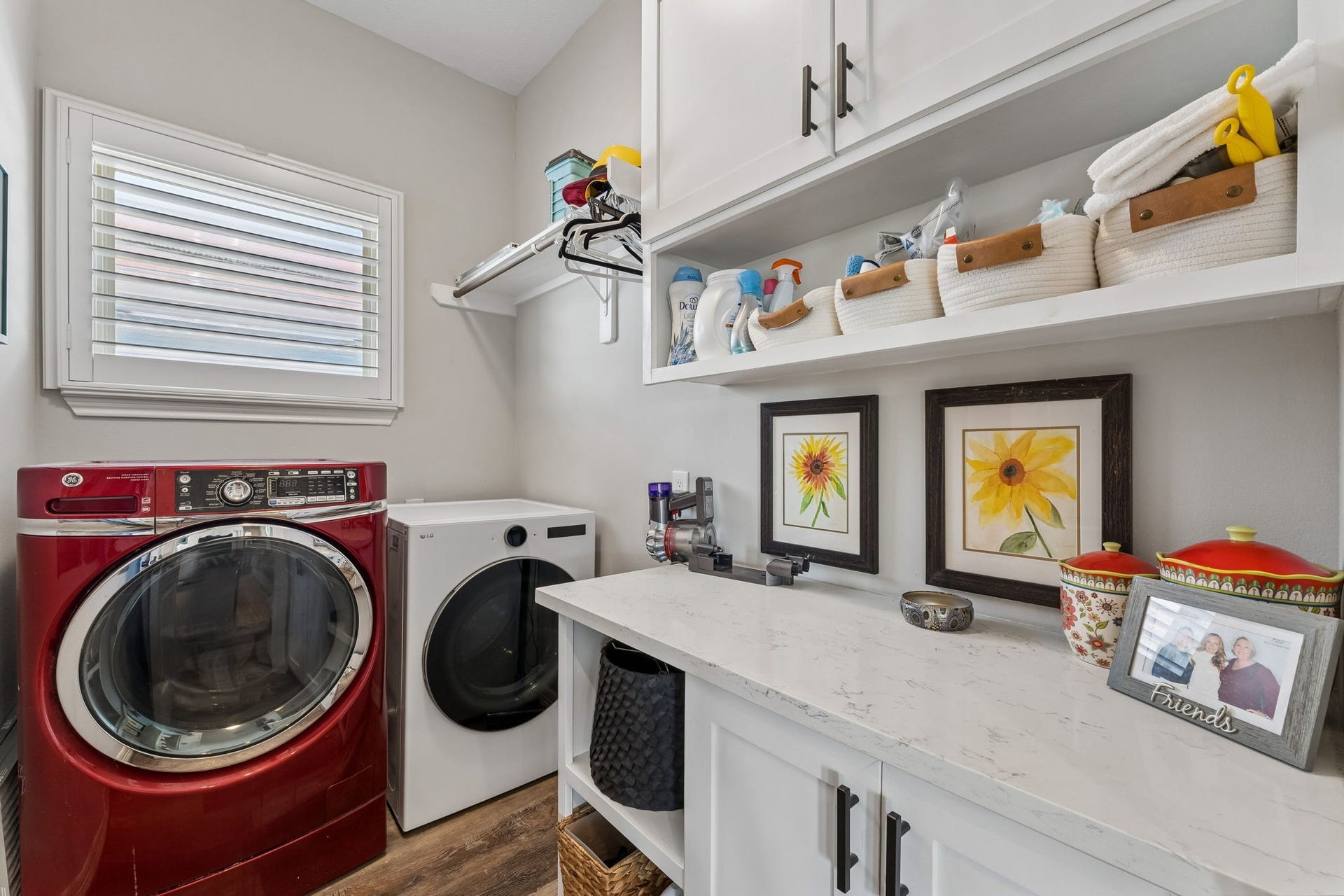 1623 Dick Bay Drive, San Leon, TX 77539 Dedicated laundry room offers generous cabinetry, counter space, and open shelving for added organization. A window brings natural light into this functional everyday space.