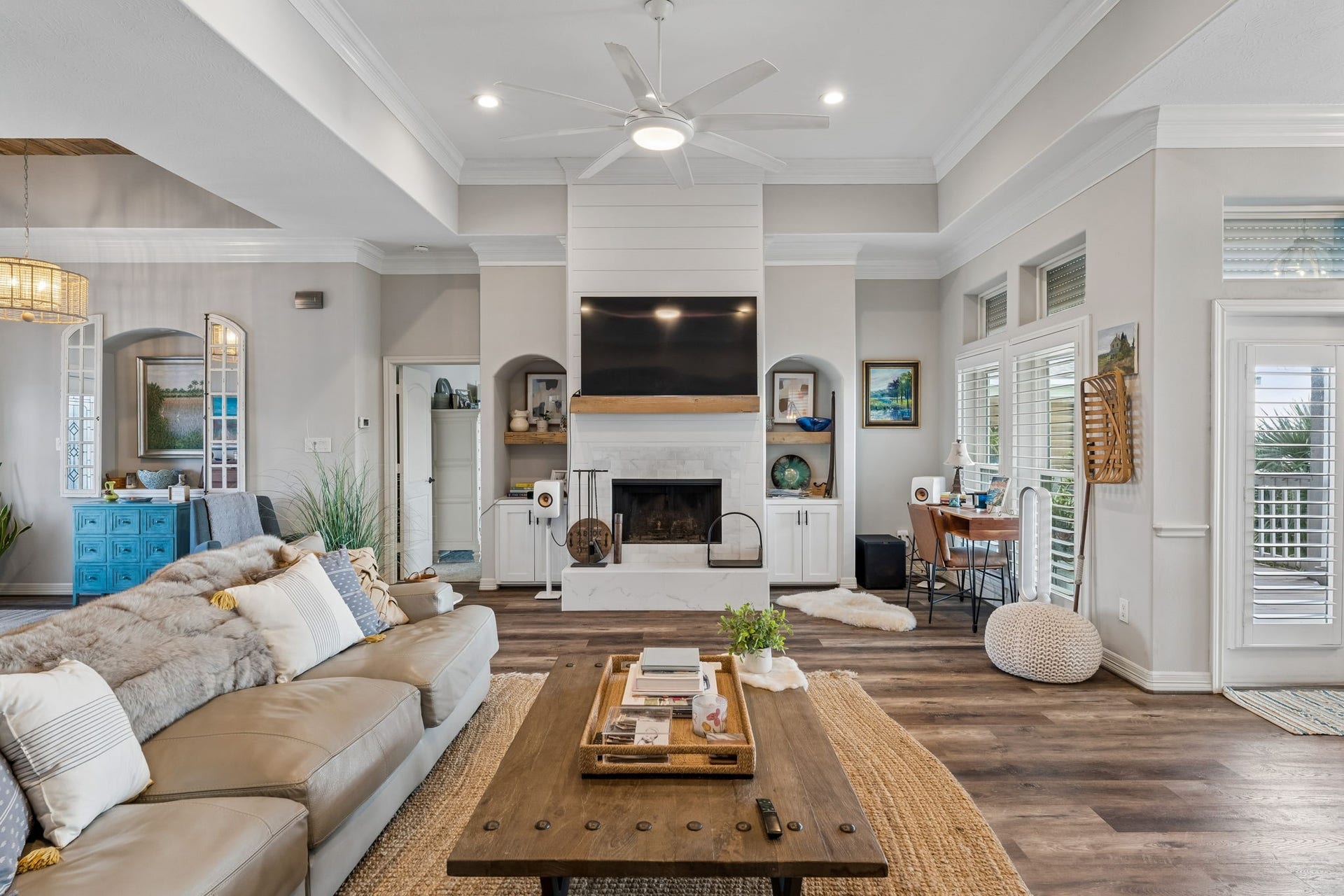 1623 Dick Bay Drive, San Leon, TX 77539 Inviting living area centered around a wood burning fireplace with custom built ins and a statement media wall. Abundant natural light and direct outdoor access enhance the bright, open feel.