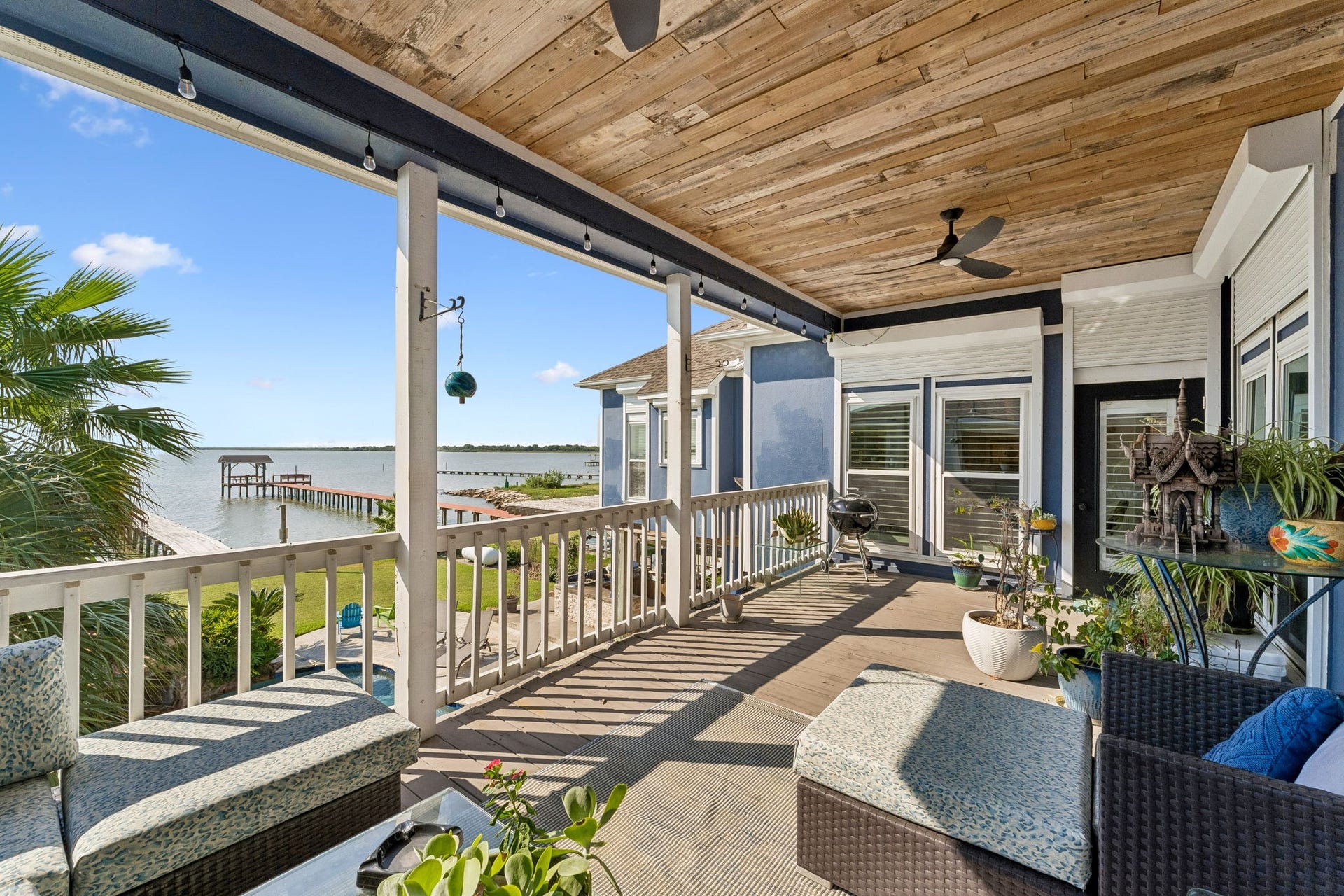 1623 Dick Bay Drive, San Leon, TX 77539 Expansive covered balcony frames sweeping views of Galveston Bay and the private pier below. A wood plank ceiling and generous seating area create an ideal setting for waterfront relaxation.