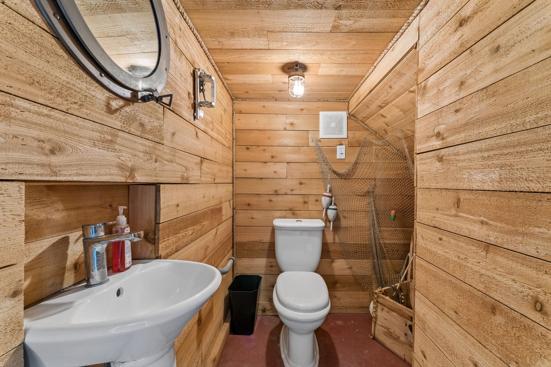 1623 Dick Bay Drive, San Leon, TX 77539 Convenient powder room features warm wood plank walls for a distinctive coastal touch. A compact design adds functionality for guests and outdoor entertaining.