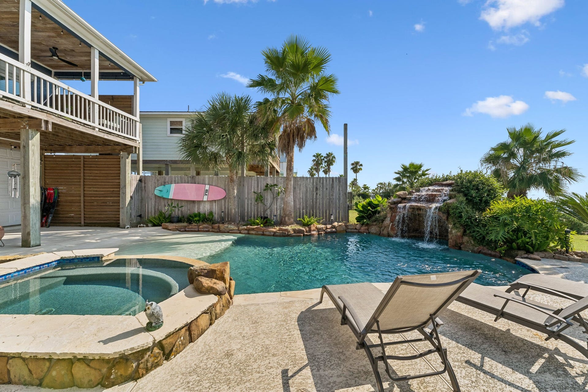 1623 Dick Bay Drive, San Leon, TX 77539 Sun drenched pool deck offers plenty of space for lounging beside the water. Tropical landscaping and the cascading waterfall create a private coastal escape.