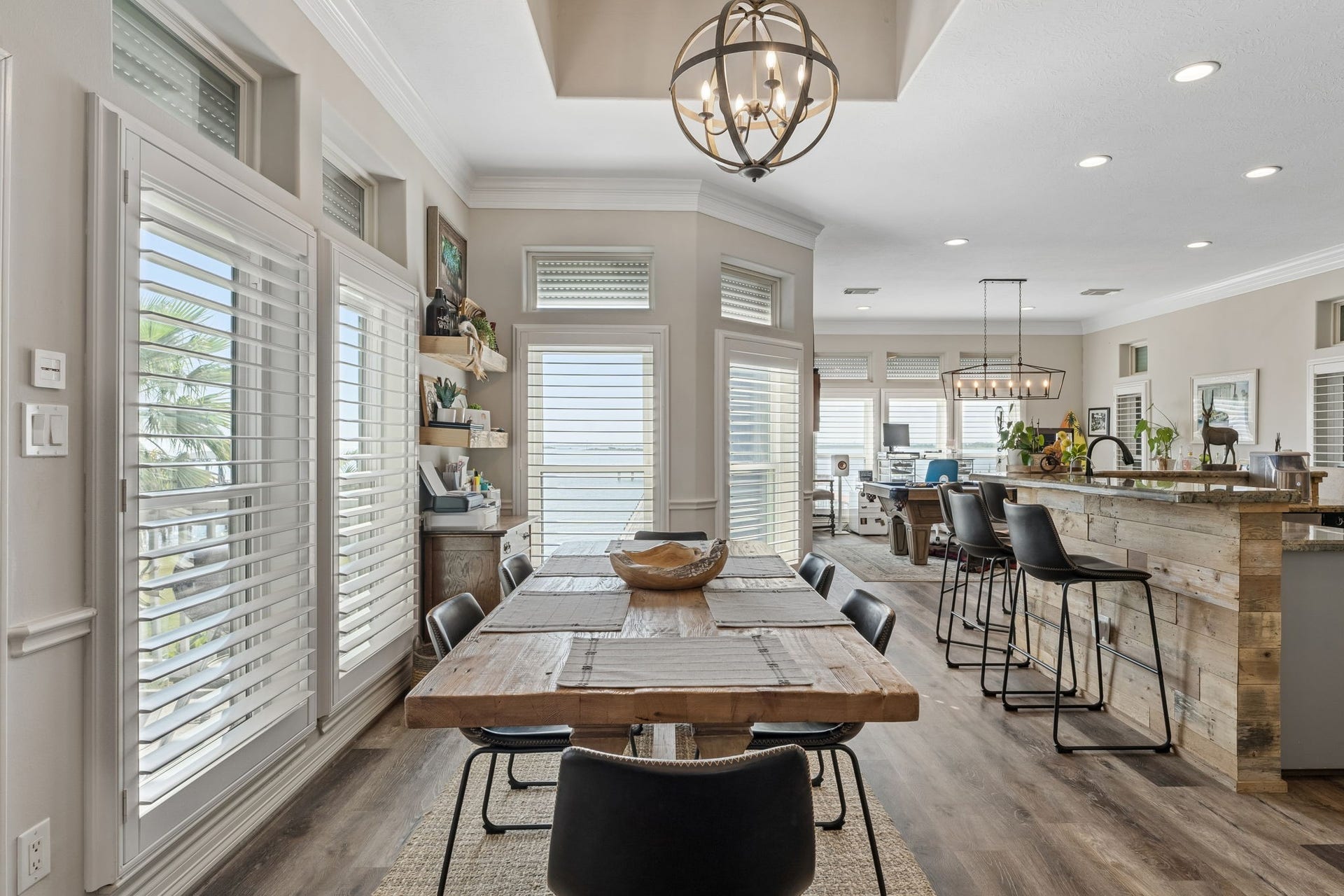 1623 Dick Bay Drive, San Leon, TX 77539 Light filled dining area flows seamlessly into the kitchen, creating an inviting space for gathering and entertaining. Expansive windows and plantation shutters bring in abundant natural light.
