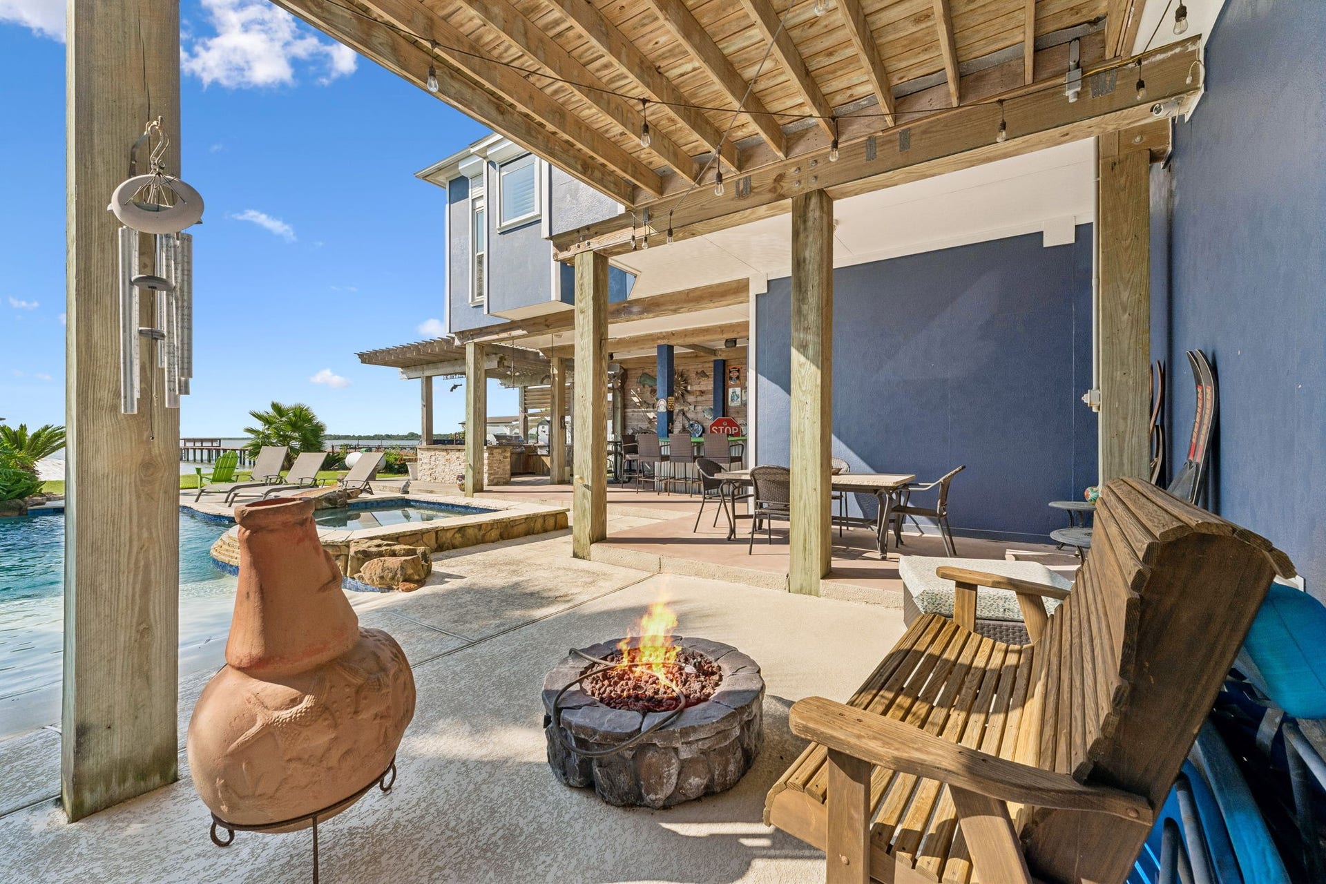 1623 Dick Bay Drive, San Leon, TX 77539 Cozy fire pit area creates the perfect spot to unwind beside the pool and waterfront. Covered seating nearby extends the outdoor living experience from day into evening.