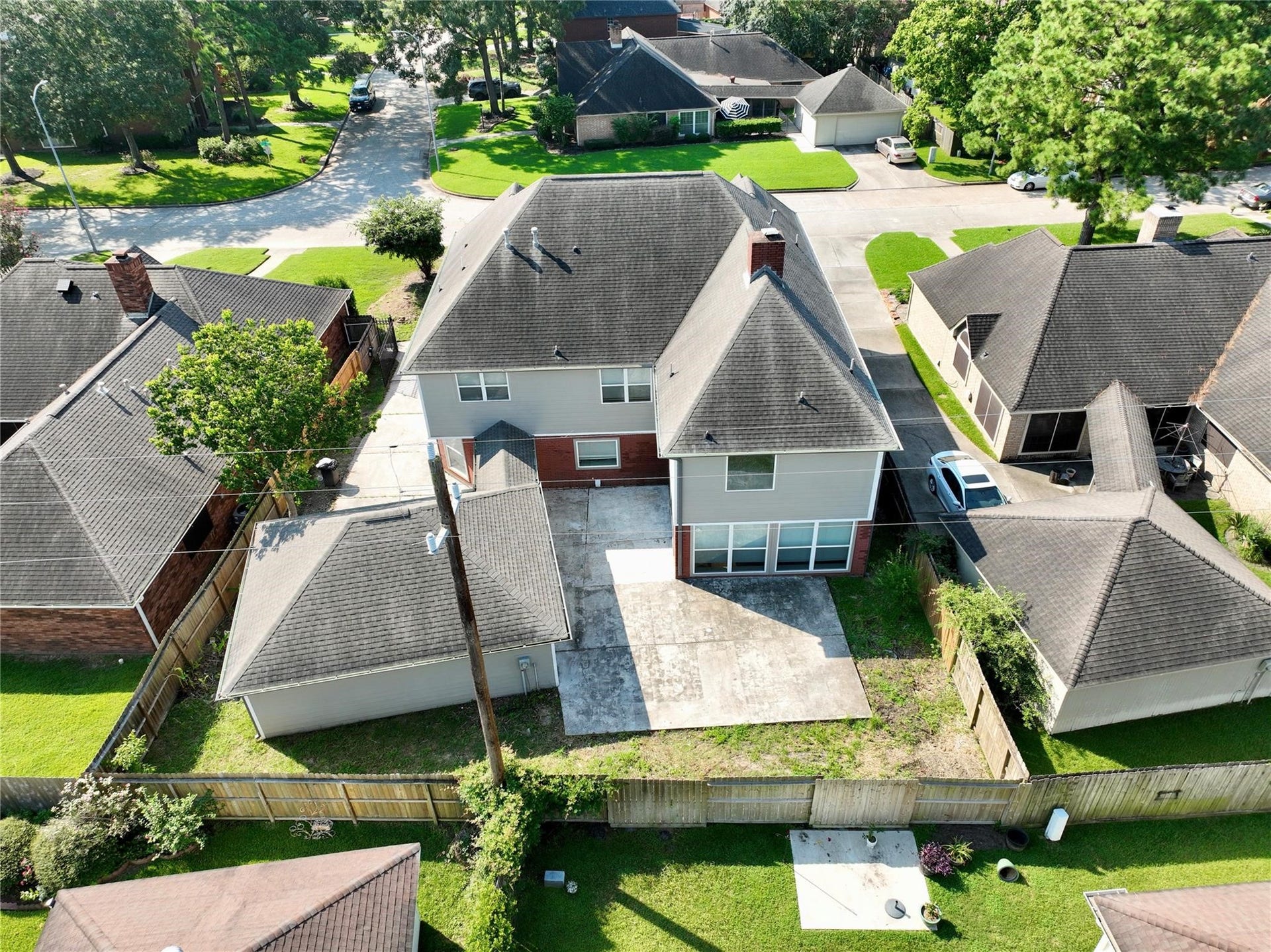 6003 Ancient Oaks Drive, Humble, TX 77346 Rear aerial view showing the home, detached garage, private driveway, fenced outdoor space, and surrounding residential community.