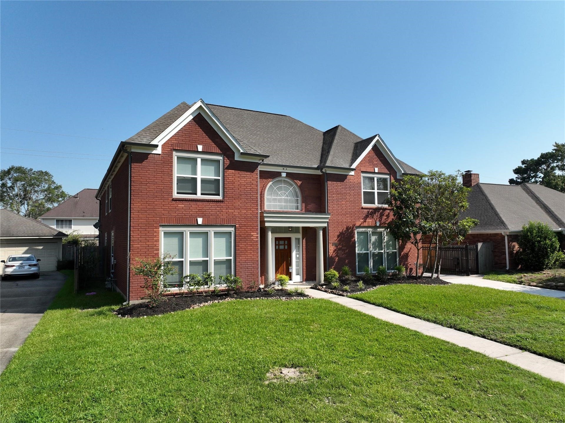 6003 Ancient Oaks Drive, Humble, TX 77346 Wide front exterior view showcasing the homes impressive curb appeal, expansive lawn, established landscaping, and two-story design.