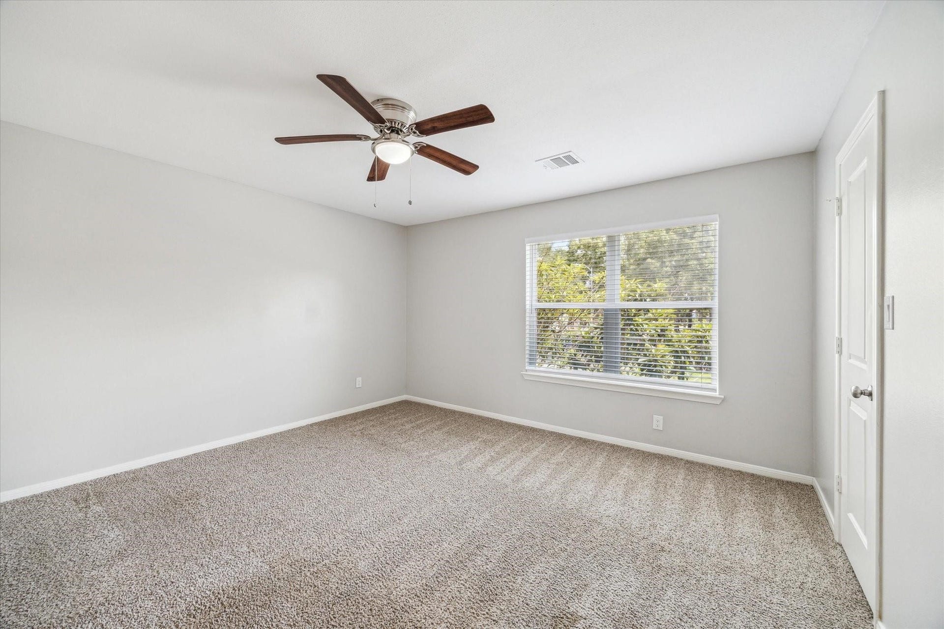 6003 Ancient Oaks Drive, Humble, TX 77346 Additional secondary bedroom offering comfortable dimensions, a ceiling fan, neutral finishes, and natural light from the window.