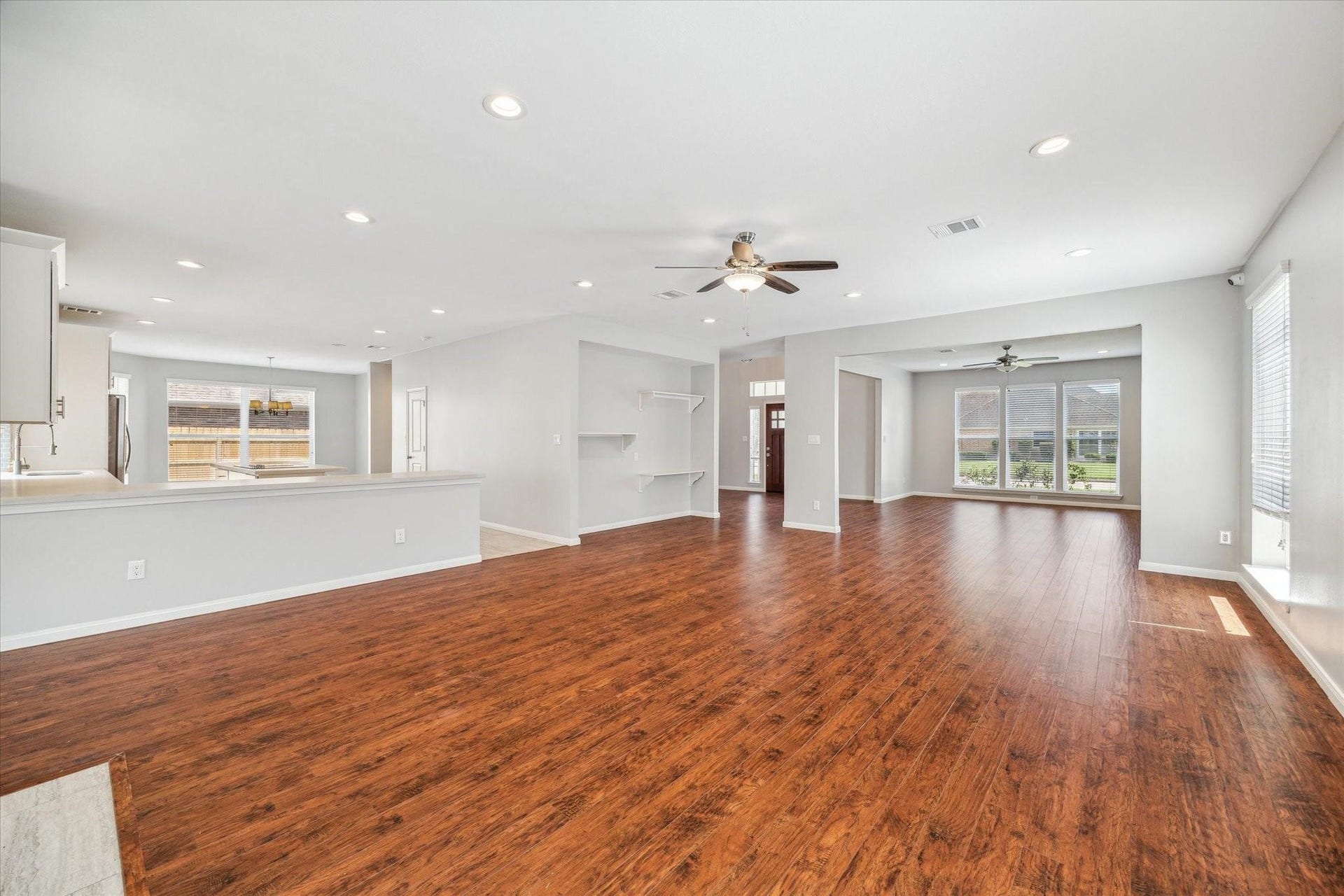 6003 Ancient Oaks Drive, Humble, TX 77346 Expansive view of the main living and entertaining areas, featuring recessed lighting, wood-look flooring, and an open connection to the remodeled kitchen.