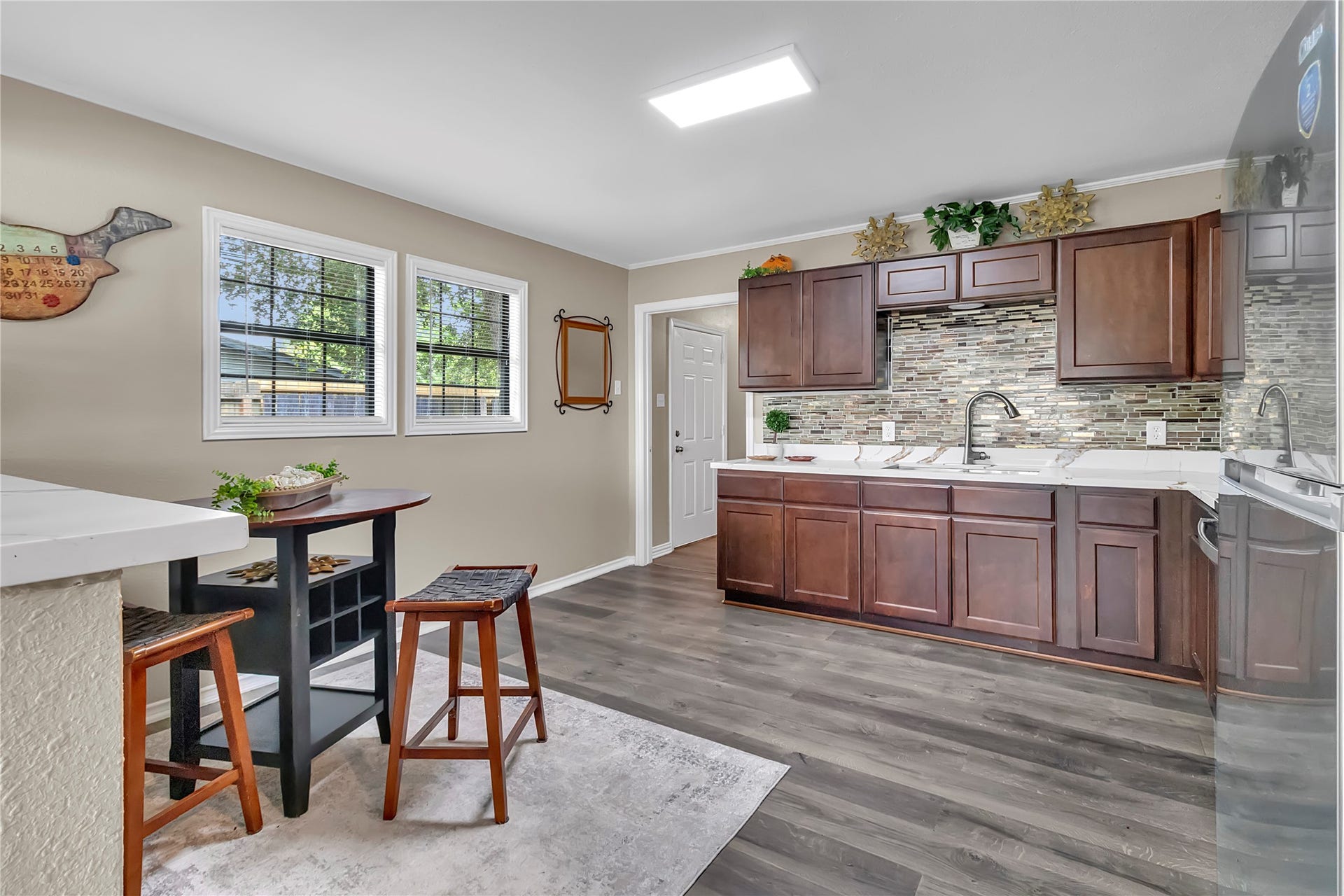 604 19th Avenue N, Texas City, TX 77590 Updated kitchen with rich cabinetry, decorative backsplash, stainless appliances, and space for casual dining.