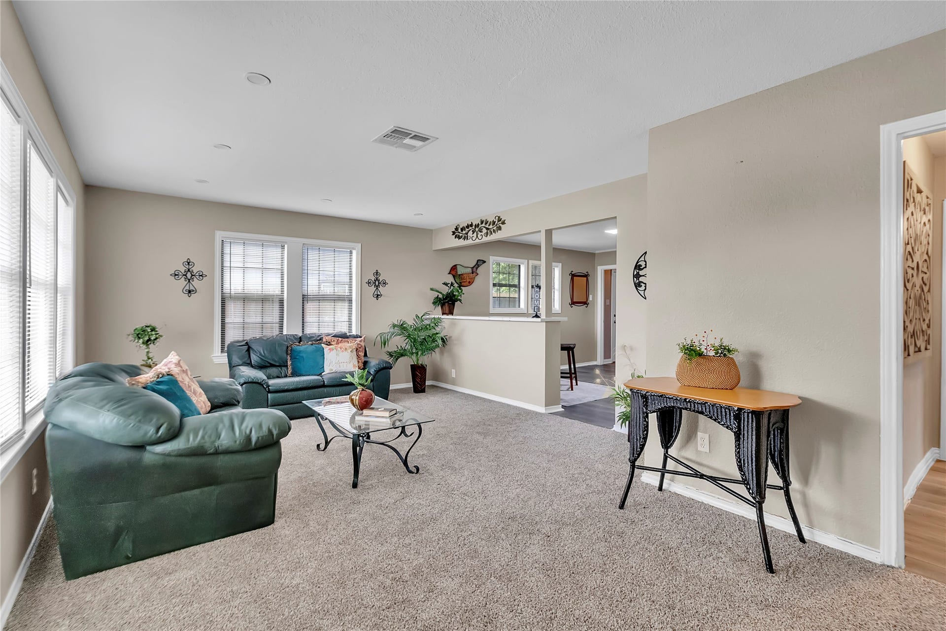 604 19th Avenue N, Texas City, TX 77590 Spacious living room with fresh carpet, large windows, and an open connection to the kitchen and adjoining living spaces.