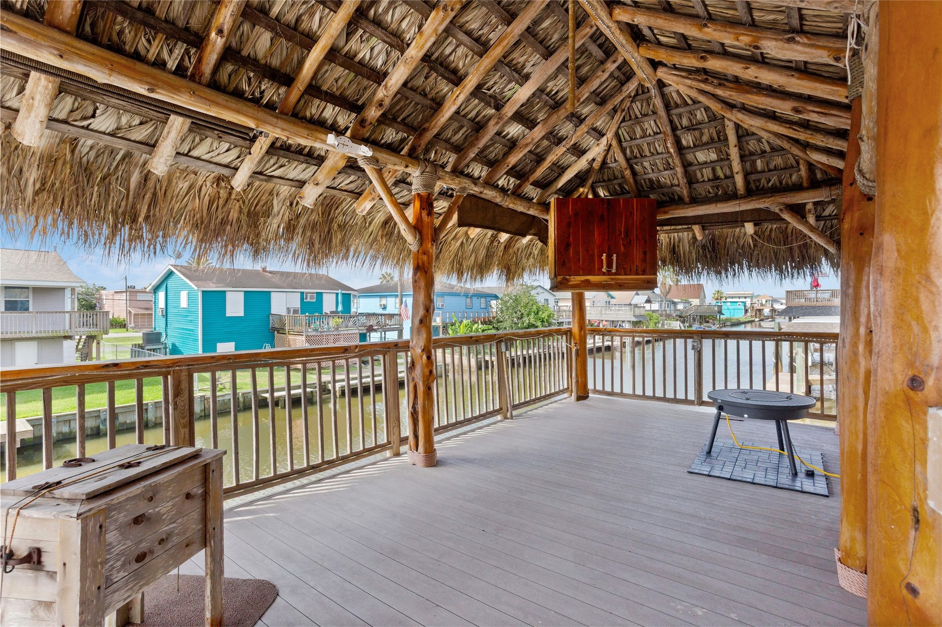 31 Lakeside Drive, Hitchcock, TX 77563 Stunning palapa bar with a cozy fire pit and TV mount, perfect for entertaining.