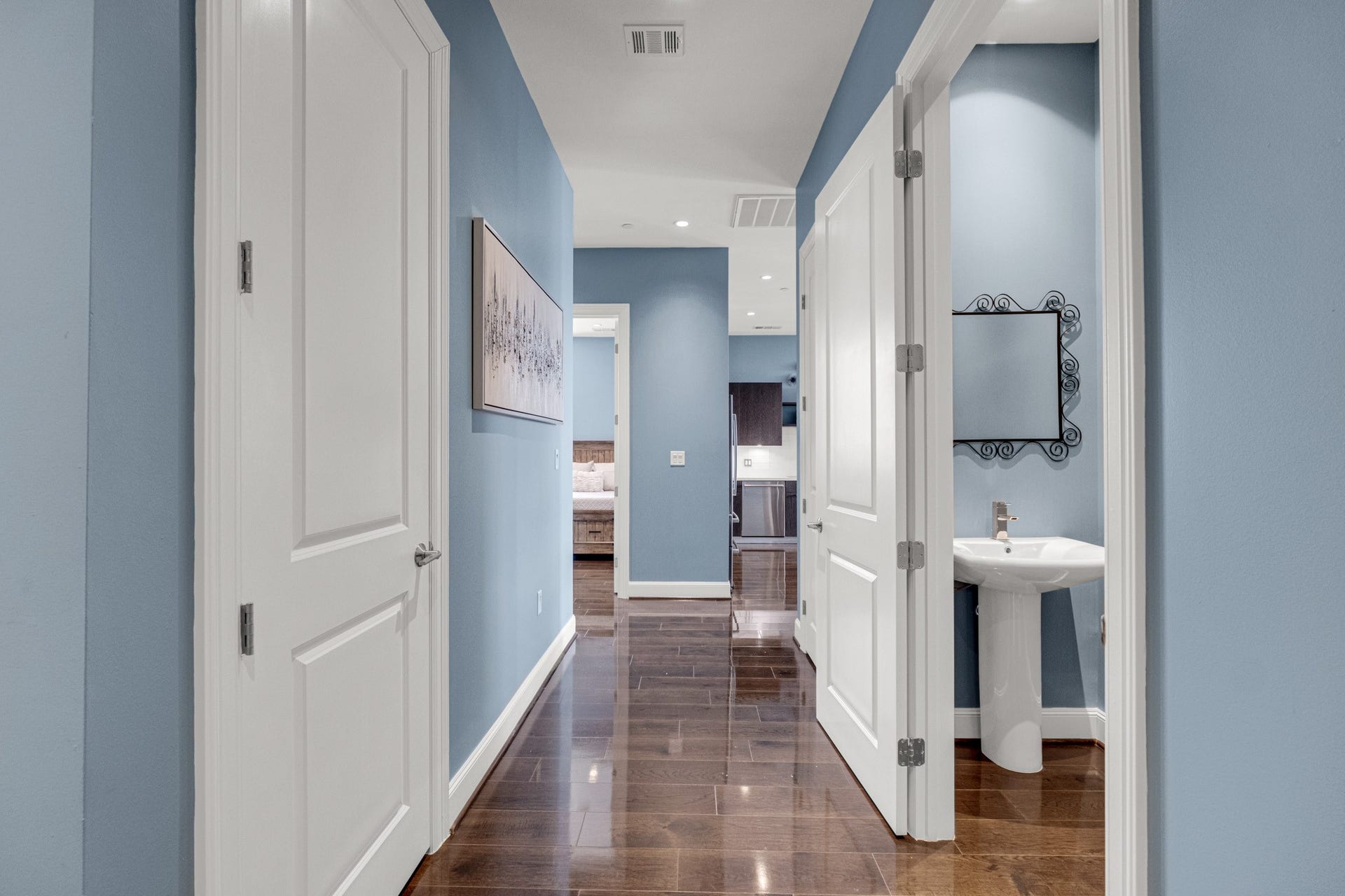 1211 Caroline Street, #1801, Houston, TX 77002 Clean, well-lit hallway with
hardwood floors, thoughtfully
connecting the half bath for
guest convenience.