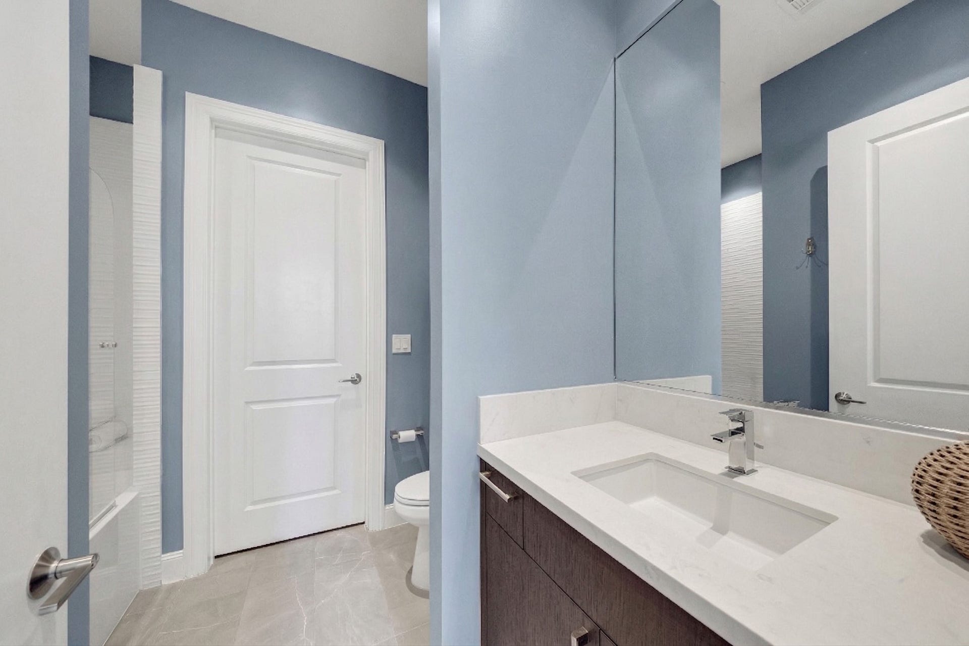 1211 Caroline Street, #1801, Houston, TX 77002 Contemporary ensuite bathroom
with a clean-lined vanity, white
quartz countertop, and a shower
with subtle tile detailing.
