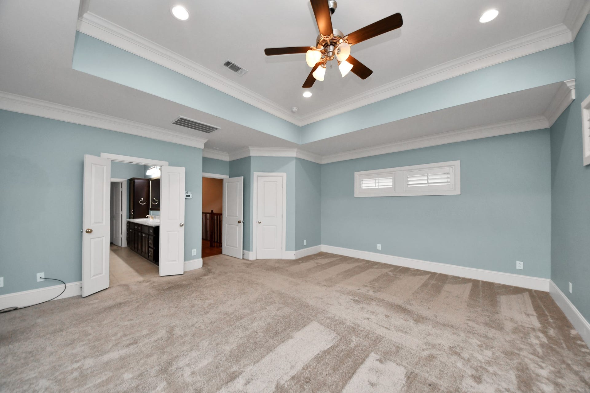 1617 W 23rd Street, Houston, TX 77008 Spacious primary bedroom with elegant tray ceilings and dual closets for ample storage.