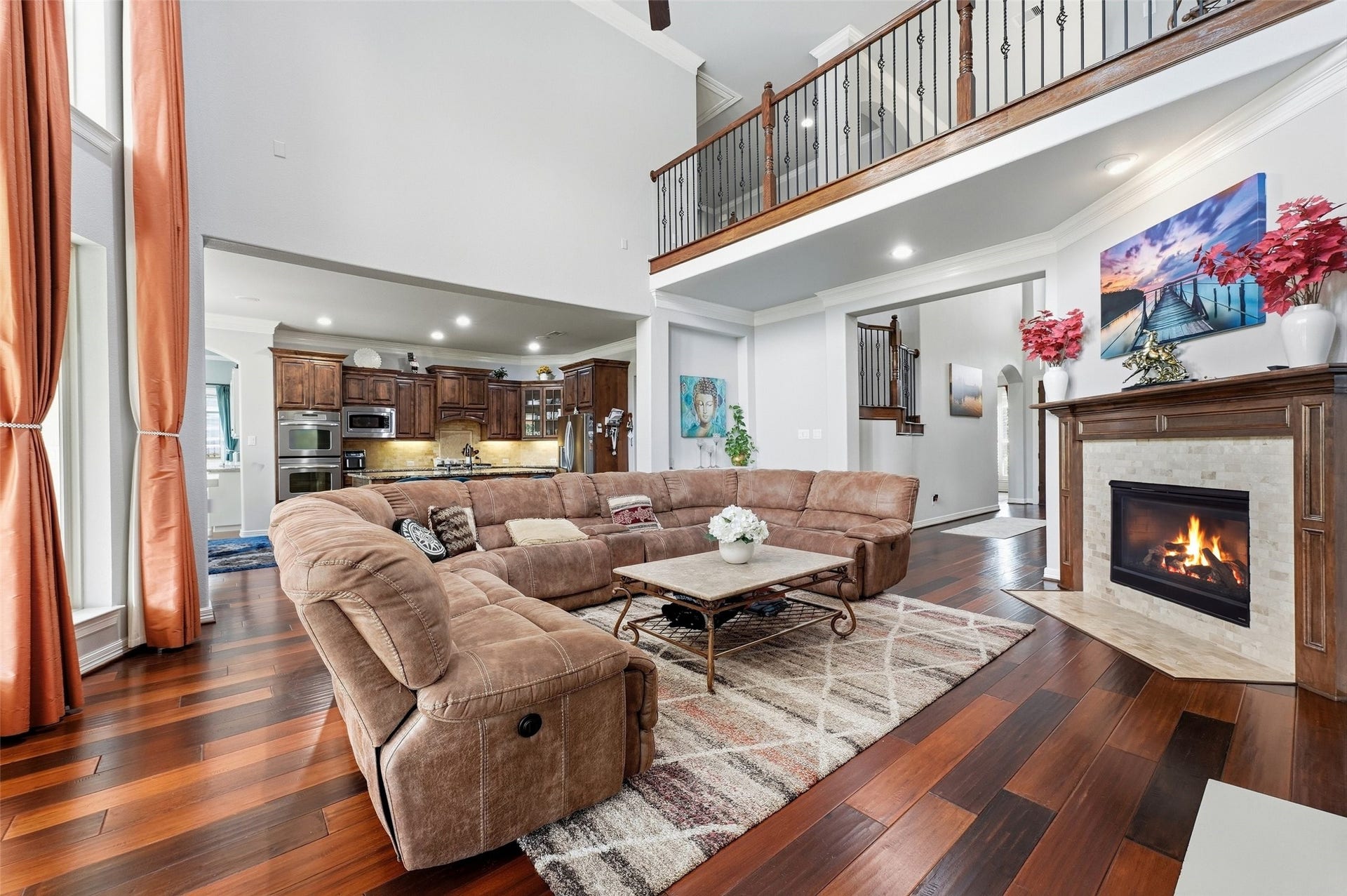 8311 Caroline Ridge Drive, Humble, TX 77396 Spacious living room with soaring ceilings, featuring a cozy fireplace and an inviting open floor plan that seamlessly connects to the elegant kitchen.