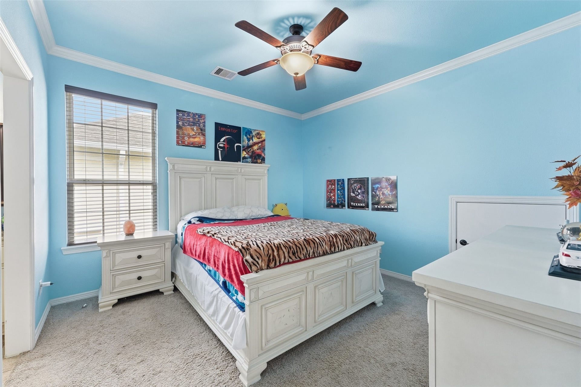 8311 Caroline Ridge Drive, Humble, TX 77396 Bright and inviting bedroom featuring elegant crown molding, and a stylish ceiling fan, complete with a large window for natural light.