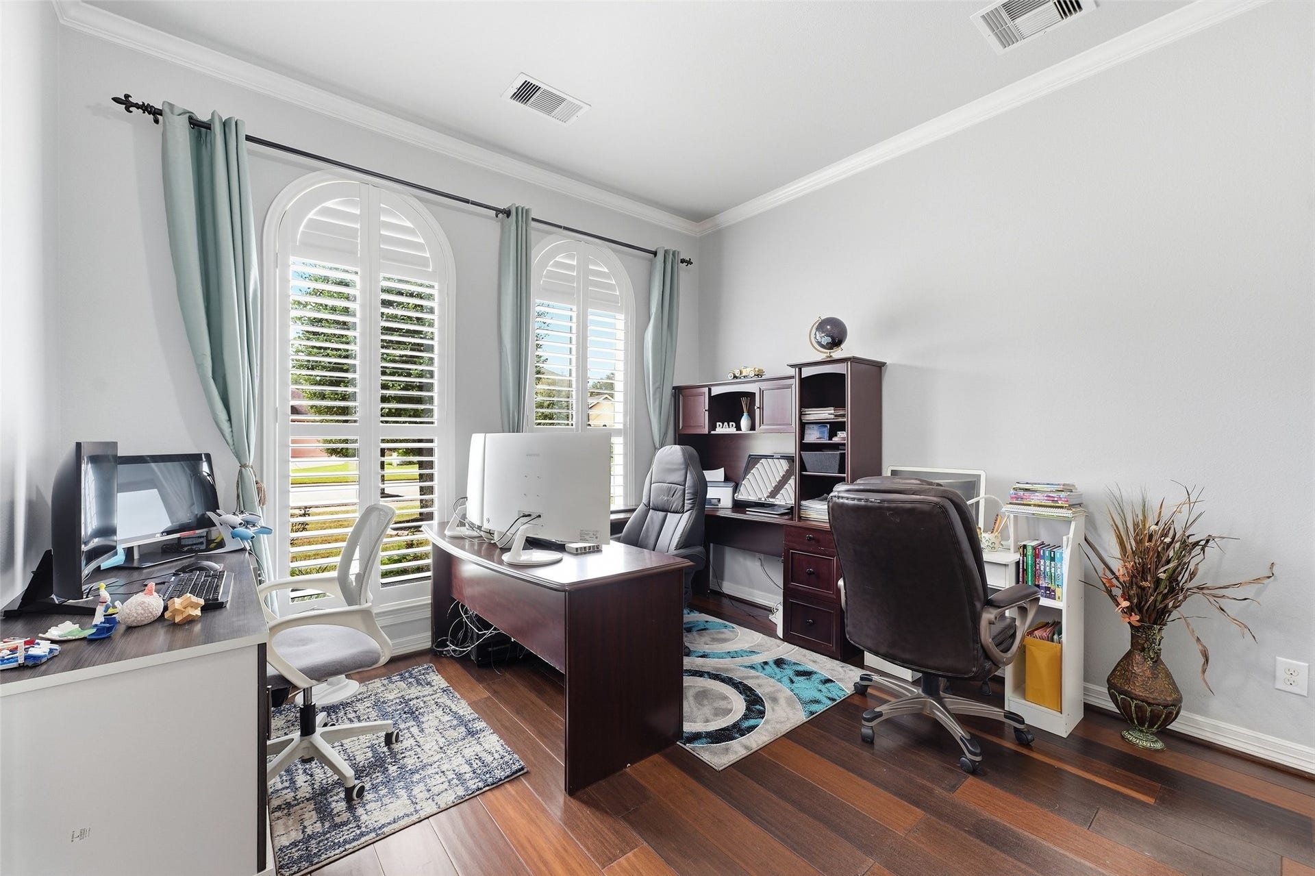 8311 Caroline Ridge Drive, Humble, TX 77396 Bright and inviting home office with large arched windows, and wood floors, perfect for productivity and comfort.