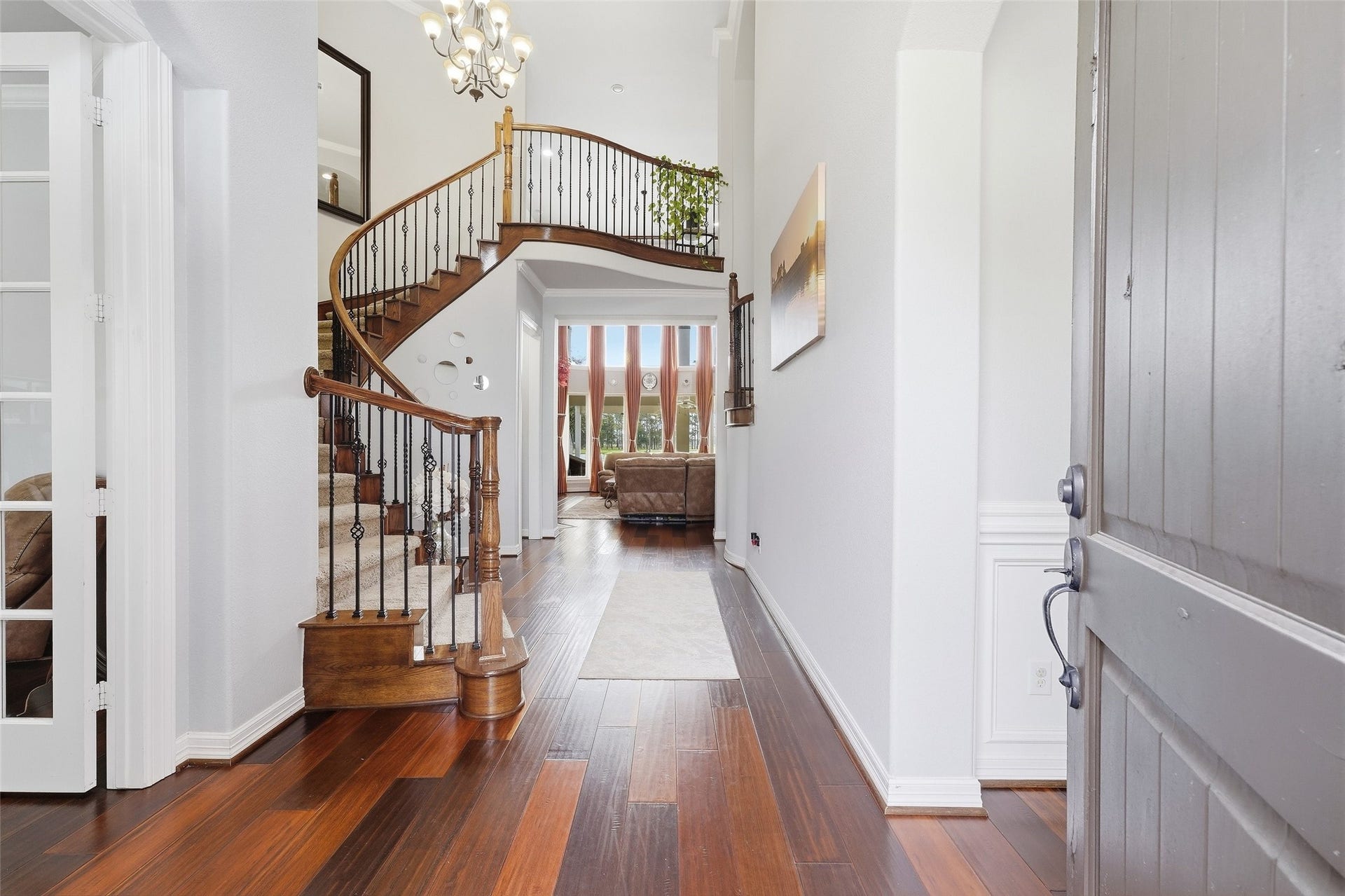 8311 Caroline Ridge Drive, Humble, TX 77396 Step into elegance with this grand entryway featuring a stunning curved staircase, rich wood floors, and abundant natural light flowing through the open living space.