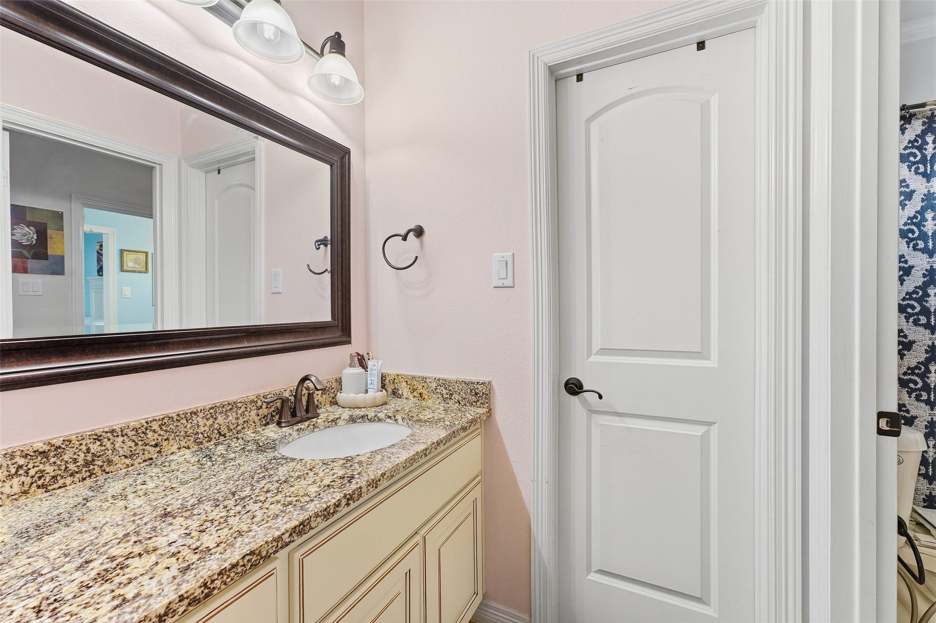8311 Caroline Ridge Drive, Humble, TX 77396 Elegant bathroom featuring a granite countertop, stylish mirror, and modern fixtures, offering a chic and functional space.