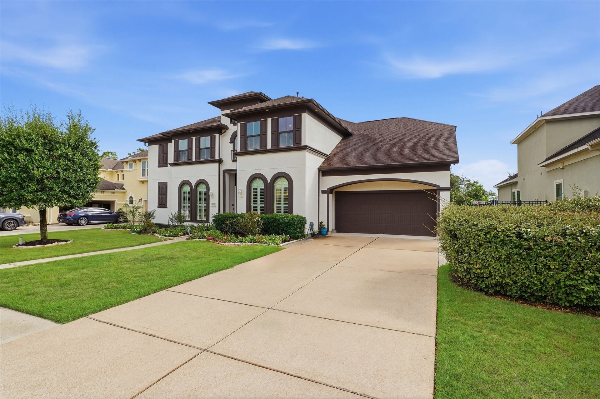 8311 Caroline Ridge Drive, Humble, TX 77396 Lovely two-story home with a classic facade, featuring arched windows, double driveway, and a spacious three-car tandem garage.