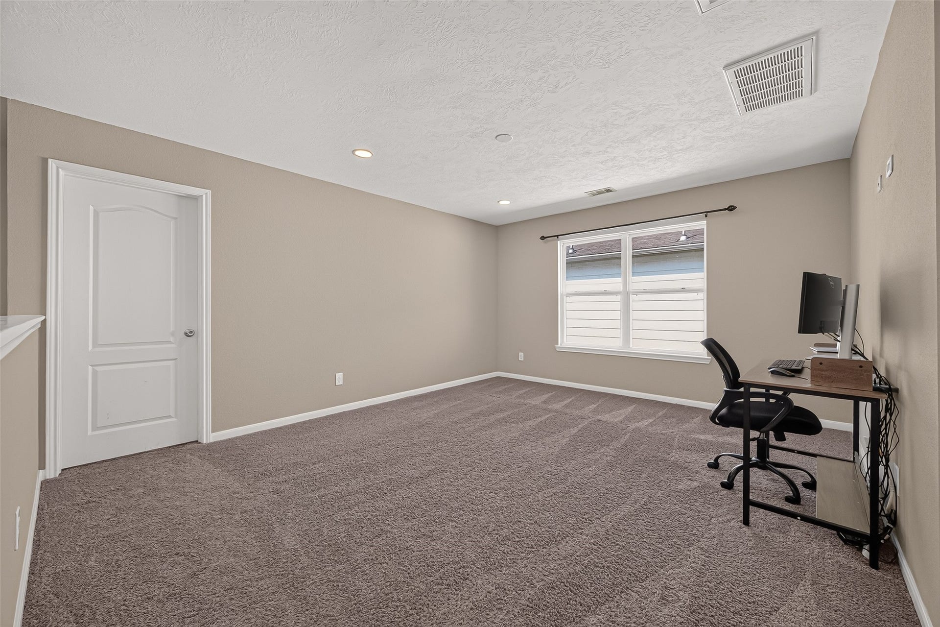 18019 Rexine Lane, Cypress, TX 77433 Spacious game room with plush carpeting, neutral walls, and recessed lighting, featuring a large window for natural light.