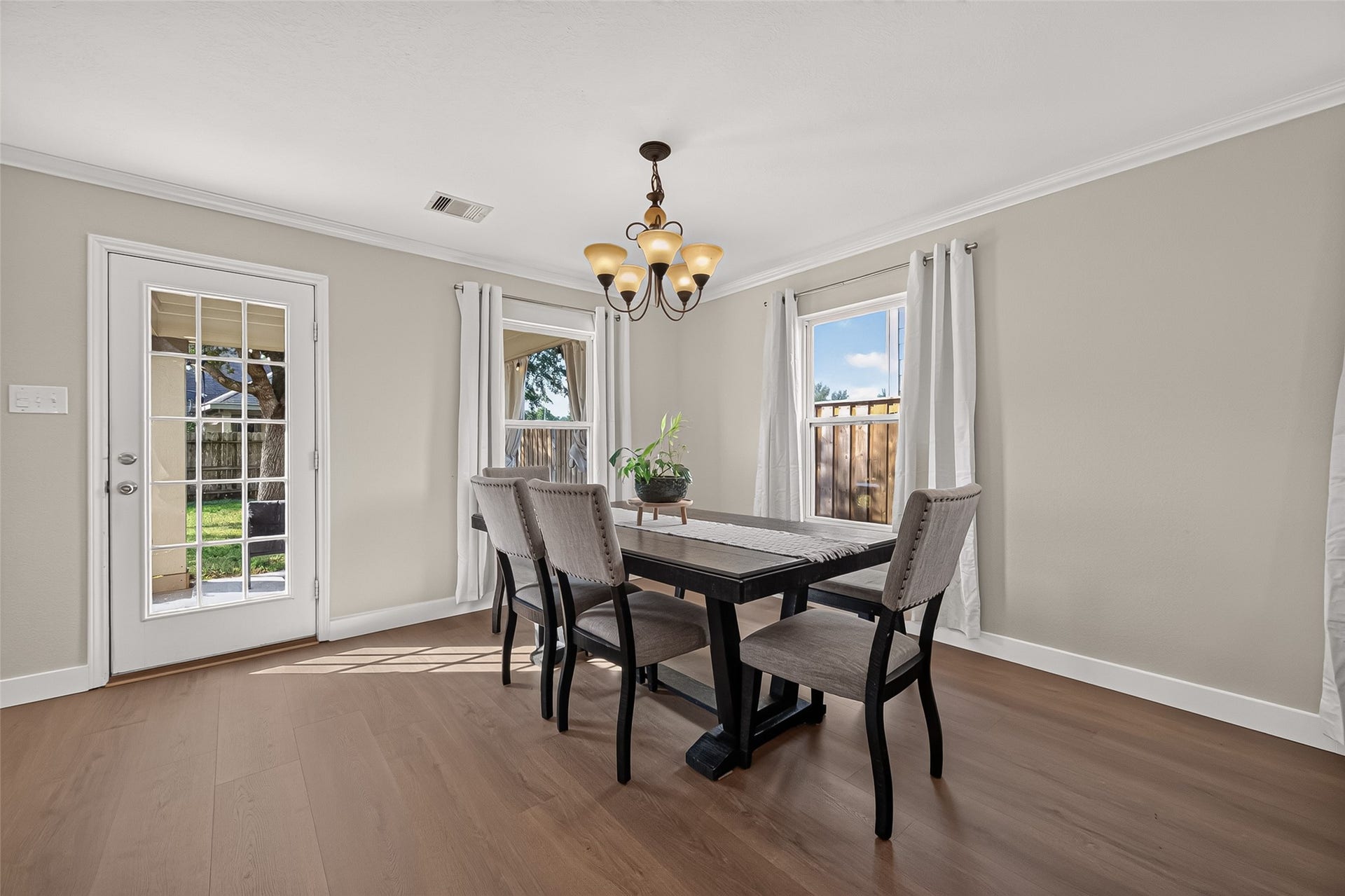18019 Rexine Lane, Cypress, TX 77433 Bright and inviting dining area with elegant vinyl plank flooring, large windows, and a stylish chandelier, perfect for family gatherings.