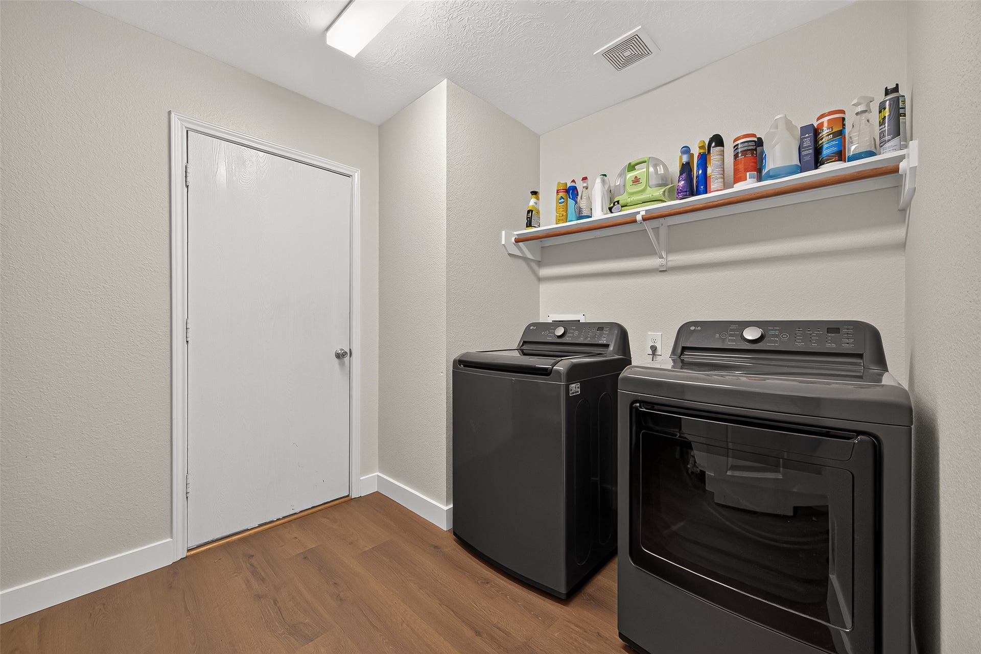 18019 Rexine Lane, Cypress, TX 77433 Spacious laundry room with modern appliances, ample shelving, and sleek vinyl plank flooring for a functional and stylish space.