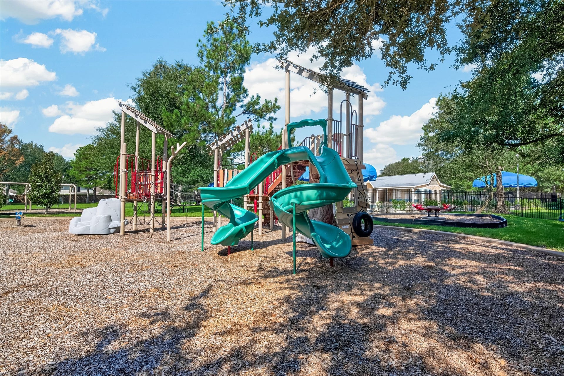 18019 Rexine Lane, Cypress, TX 77433 Charming community playground featuring vibrant slides, climbing structures, and shaded areas, perfect for family fun and outdoor activities.