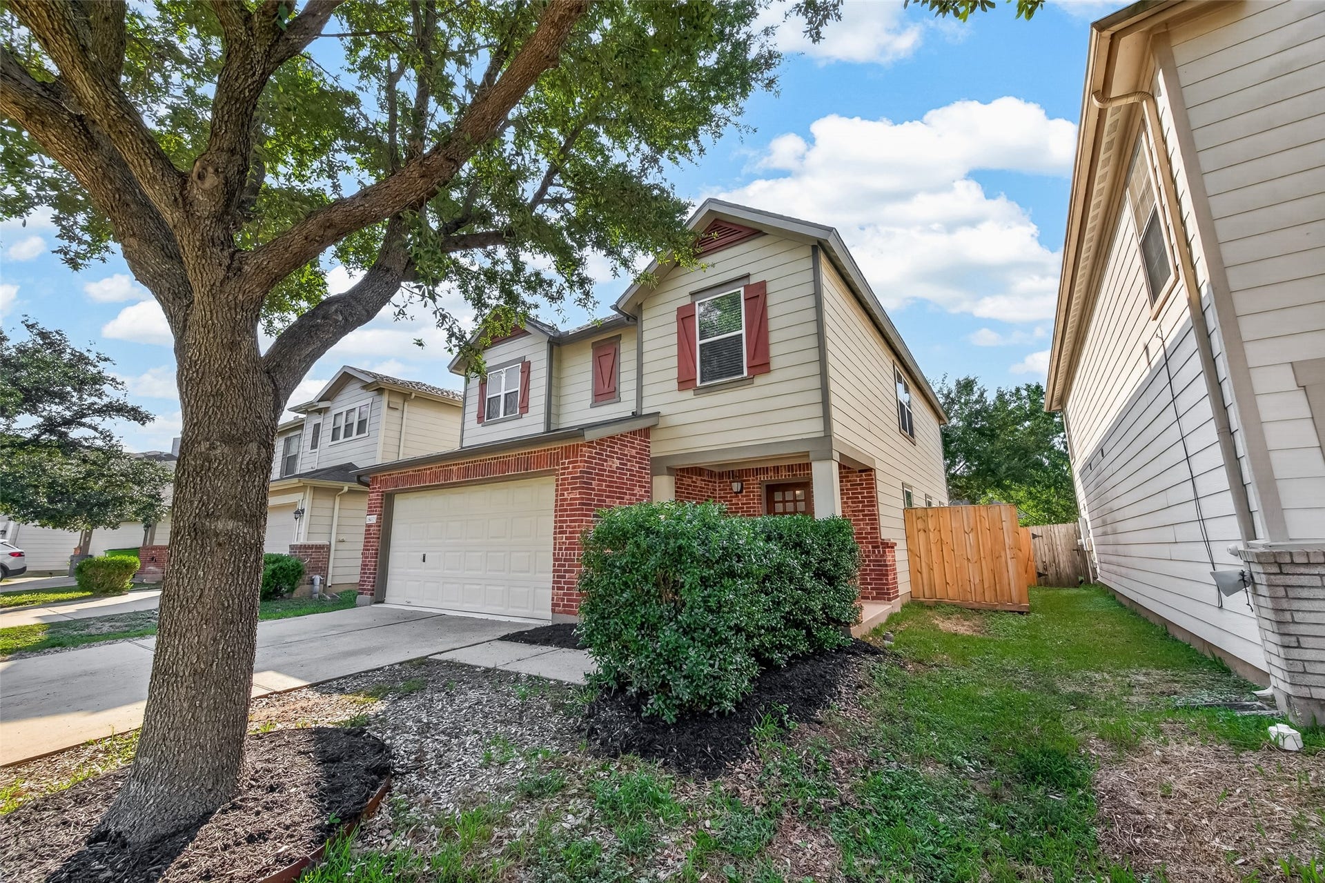18019 Rexine Lane, Cypress, TX 77433 Charming two-story home with a brick faade, nestled on a tree-lined street, featuring a spacious two-car garage and a welcoming front yard.