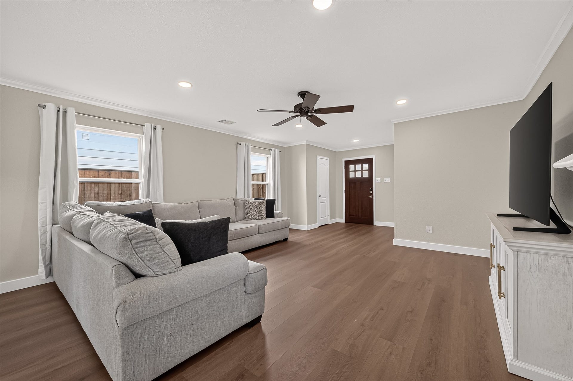 18019 Rexine Lane, Cypress, TX 77433 Spacious living room with elegant vinyl plank flooring and abundant natural light from large windows, perfect for relaxation and entertainment.