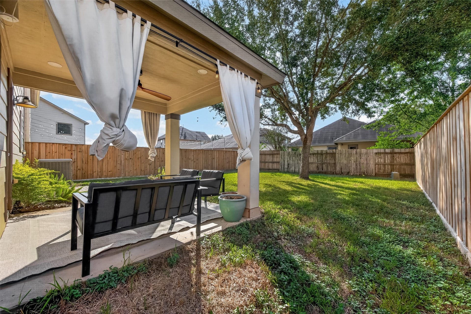 18019 Rexine Lane, Cypress, TX 77433 Charming backyard oasis with a cozy covered patio, perfect for outdoor relaxation, surrounded by lush greenery and a privacy fence.
