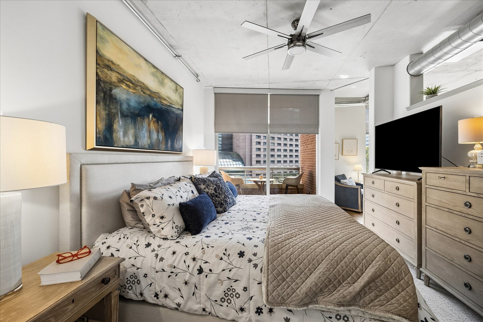 Spacious bedroom and a private balcony with city views.