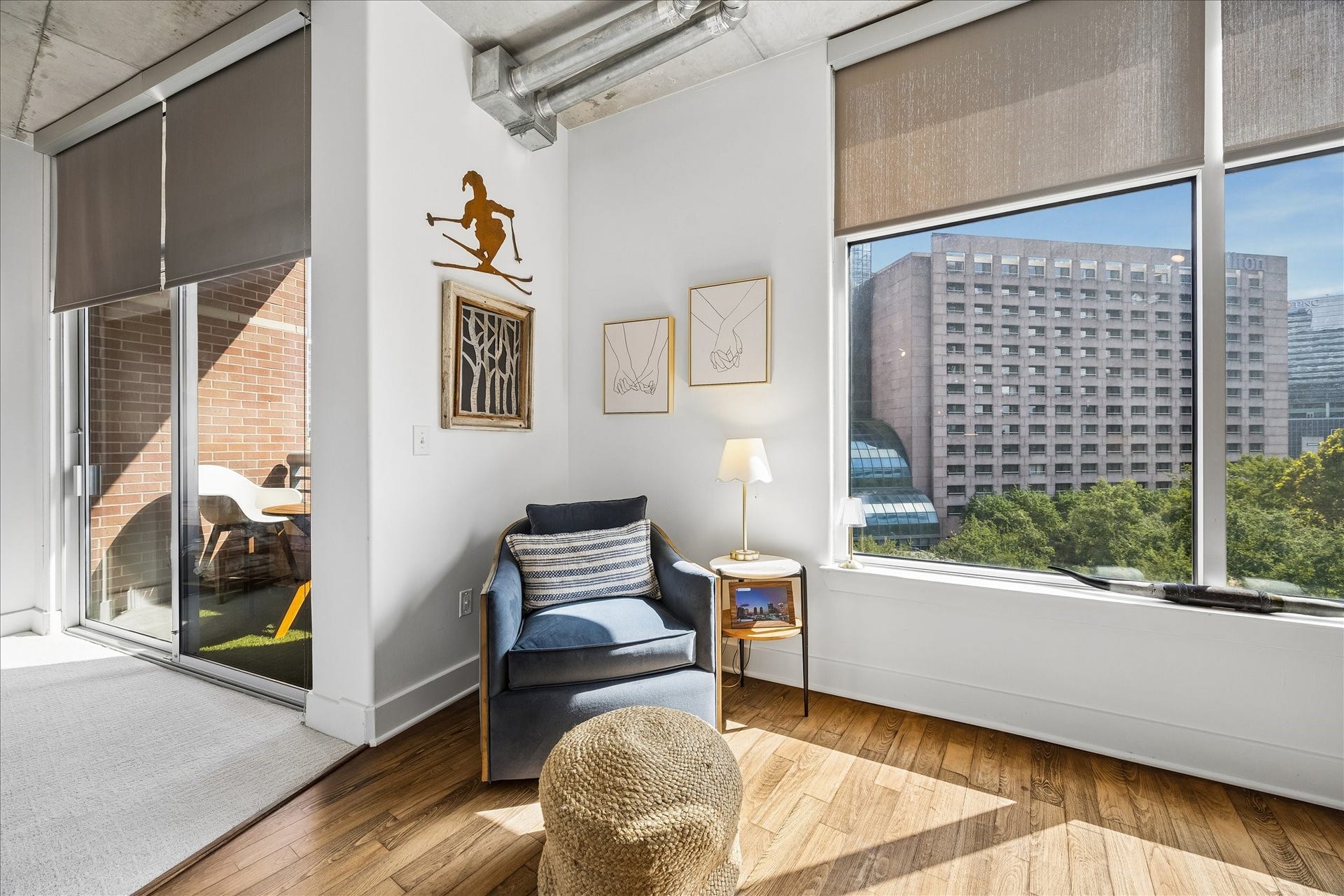 A cozy reading nook with views of the city with lush trees and landscaping below.