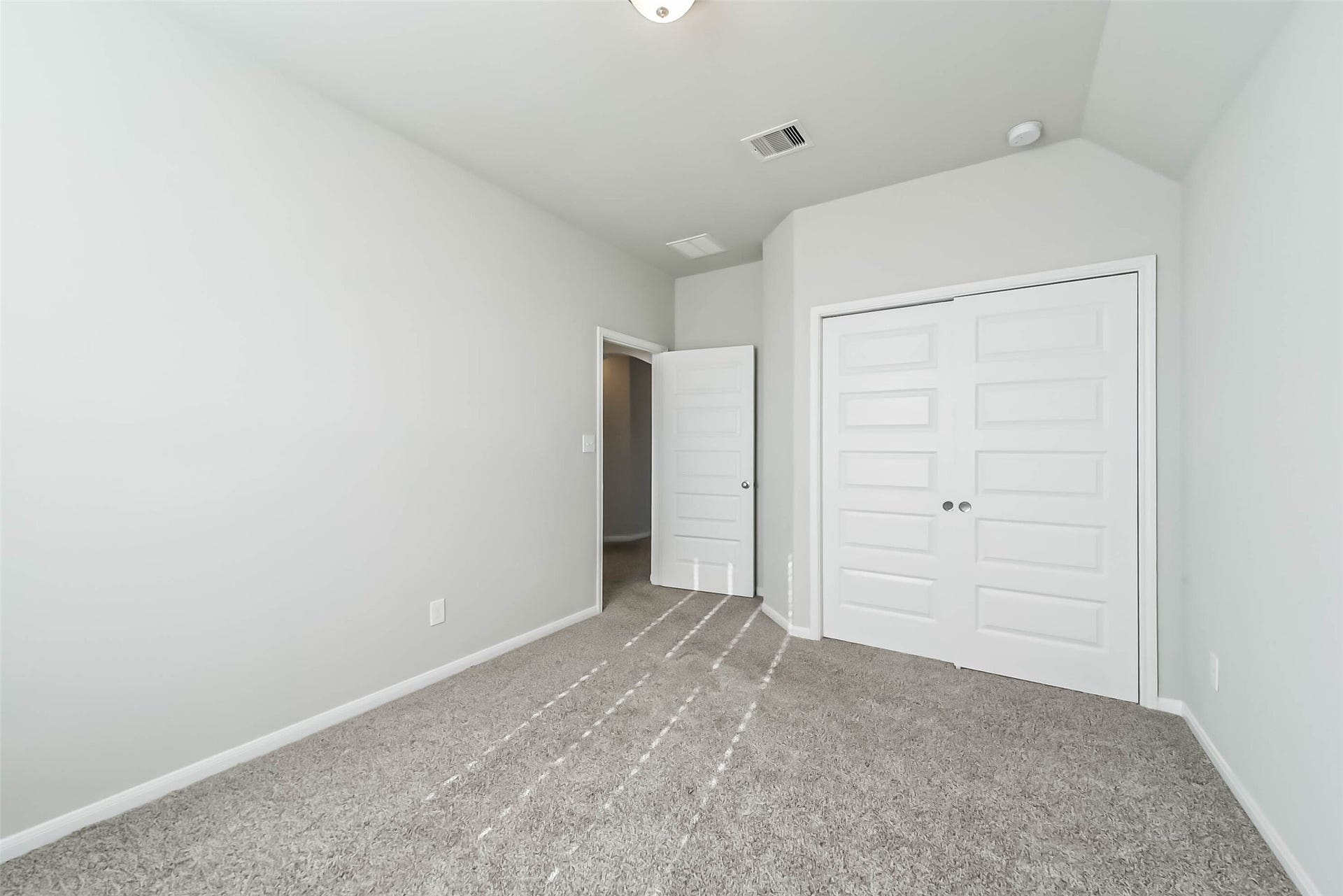 Bright secondary bedroom with neutral finishes.