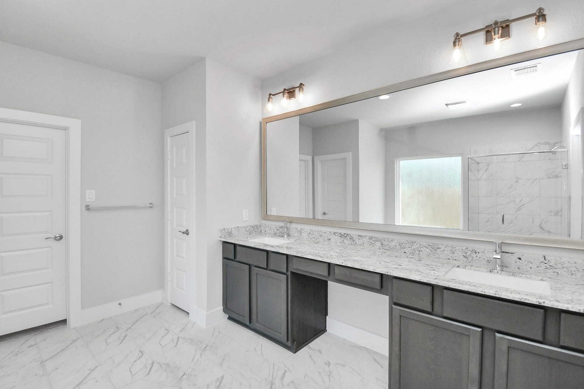 3114 Native Spring Drive, Spring, TX 77373 Escape to a spa-like oasis in this primary bathroom. Enjoy a walk-in shower with tile surround, a separate garden tub with custom detailing, and an elegant vanity featuring light countertops, modern hardware, and beautiful vanity lights. Experience luxury and relaxation in every detail. Sample photo of completed home with similar floor plan. Actual colors and selections may vary.