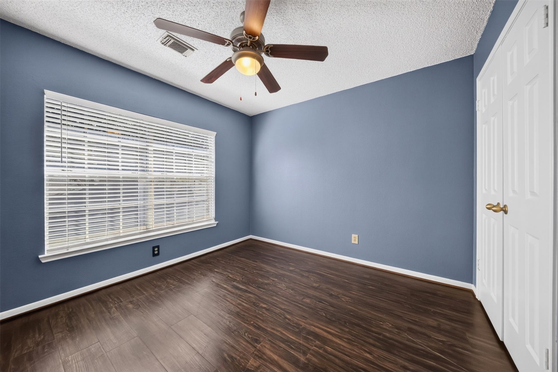 10215 Minturn Lane, Houston, TX 77064 Bedroom with blue walls, wood look flooring, ceiling fan, and large window.