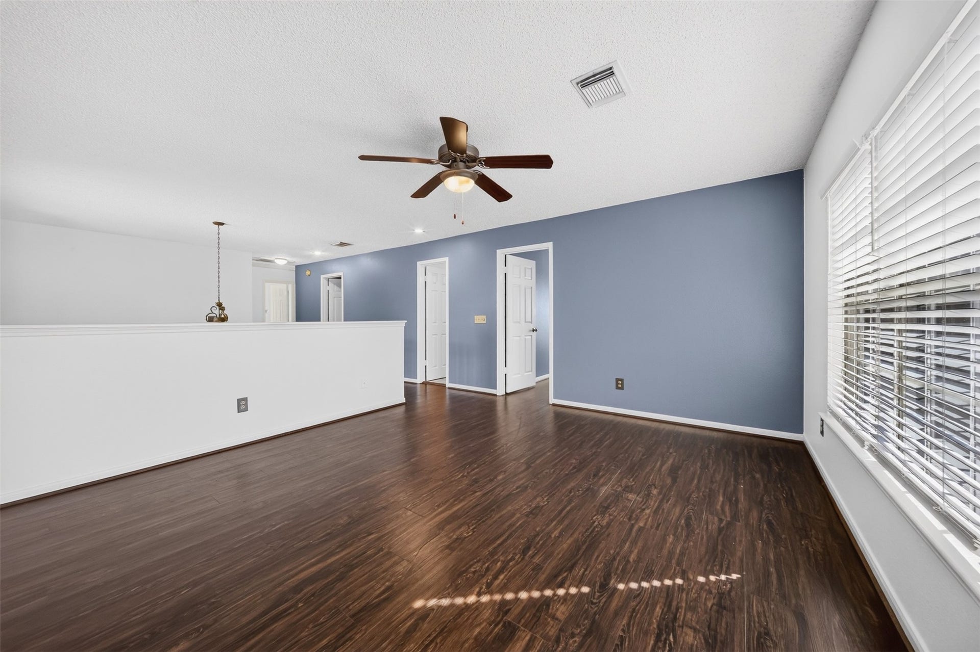 10215 Minturn Lane, Houston, TX 77064 Spacious upstairs room featuring wood look flooring, ceiling fan, and natural light.