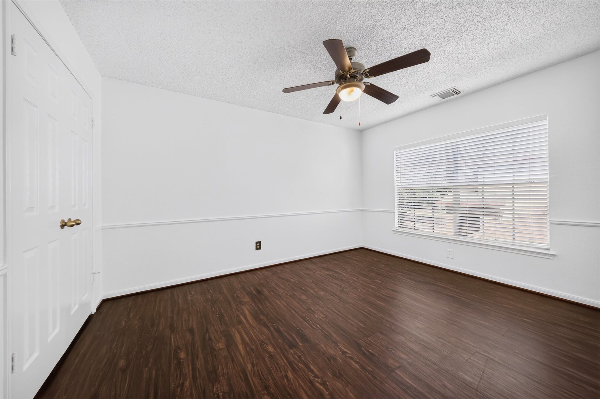 10215 Minturn Lane, Houston, TX 77064 Spacious bedroom with wood look flooring, ceiling fan, and natural light.