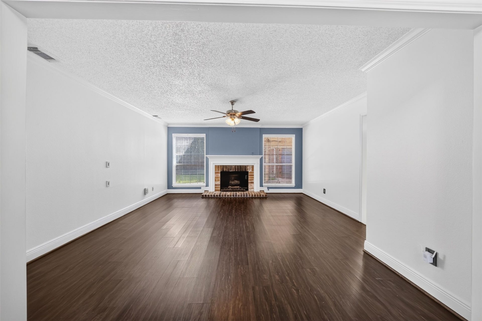 10215 Minturn Lane, Houston, TX 77064 Spacious living room featuring wood-look flooring, fireplace, and an open layout.