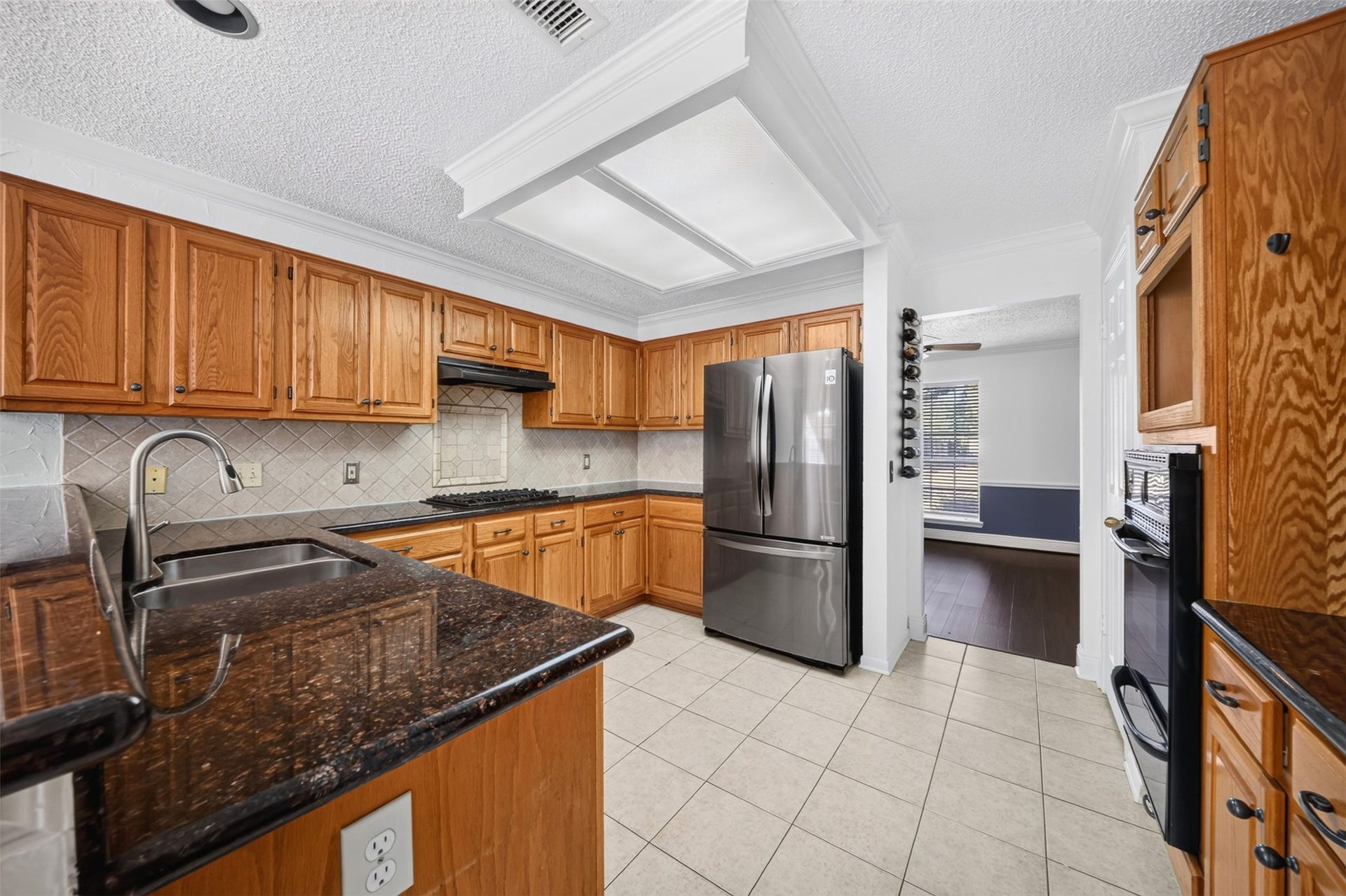 10215 Minturn Lane, Houston, TX 77064 Kitchen featuring wood cabinetry, dark countertops, stainless steel appliances, and ample storage.