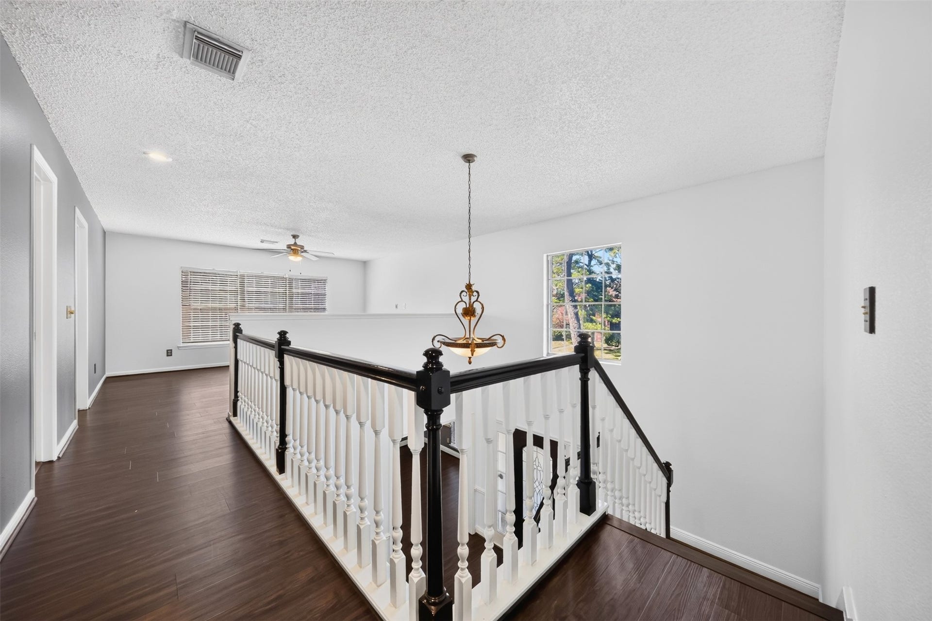 10215 Minturn Lane, Houston, TX 77064 Upstairs landing with wood-look flooring, staircase railing, and natural light.