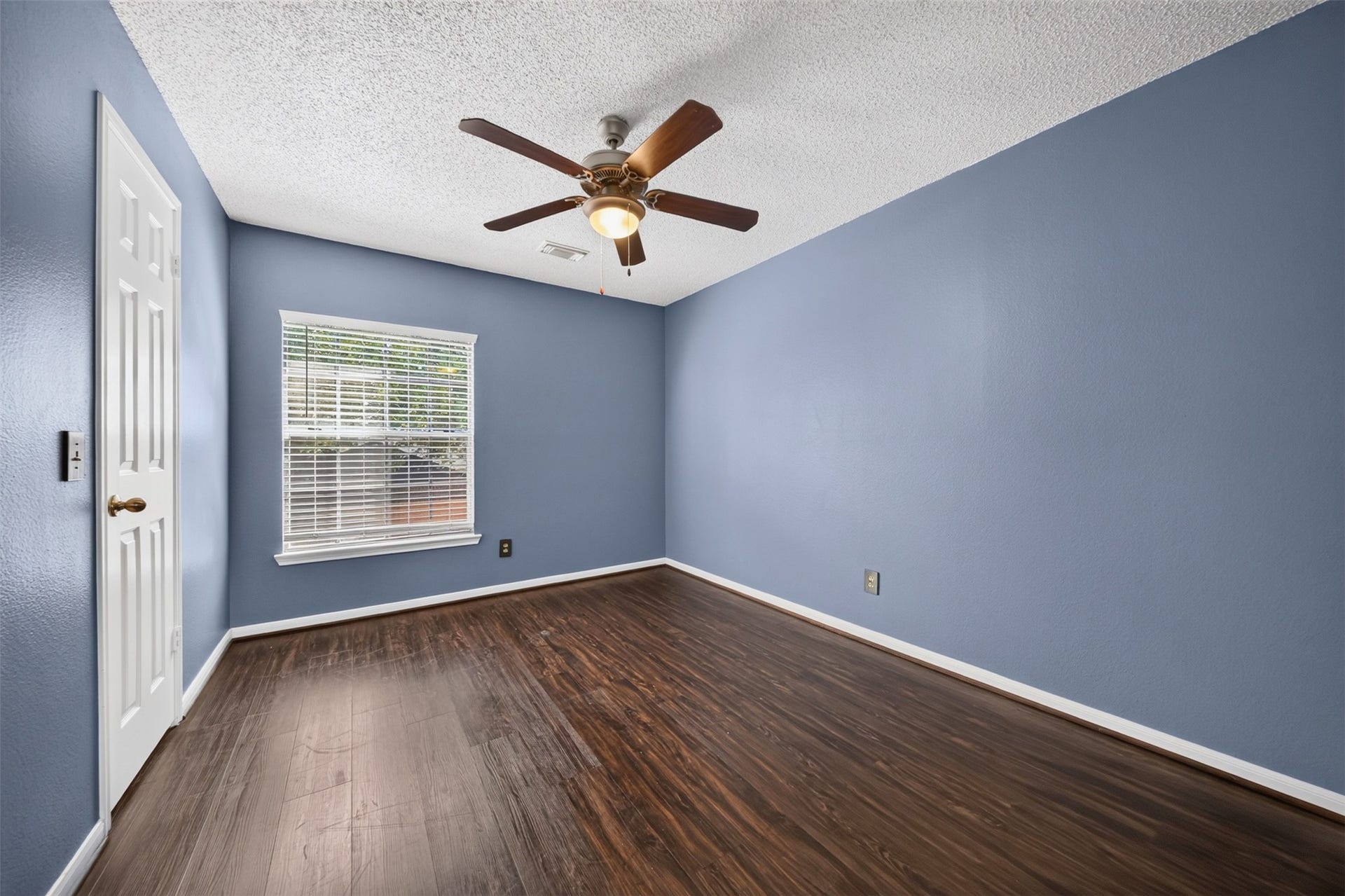 10215 Minturn Lane, Houston, TX 77064 Additional bedroom with blue walls, wood look flooring, and ceiling fan.